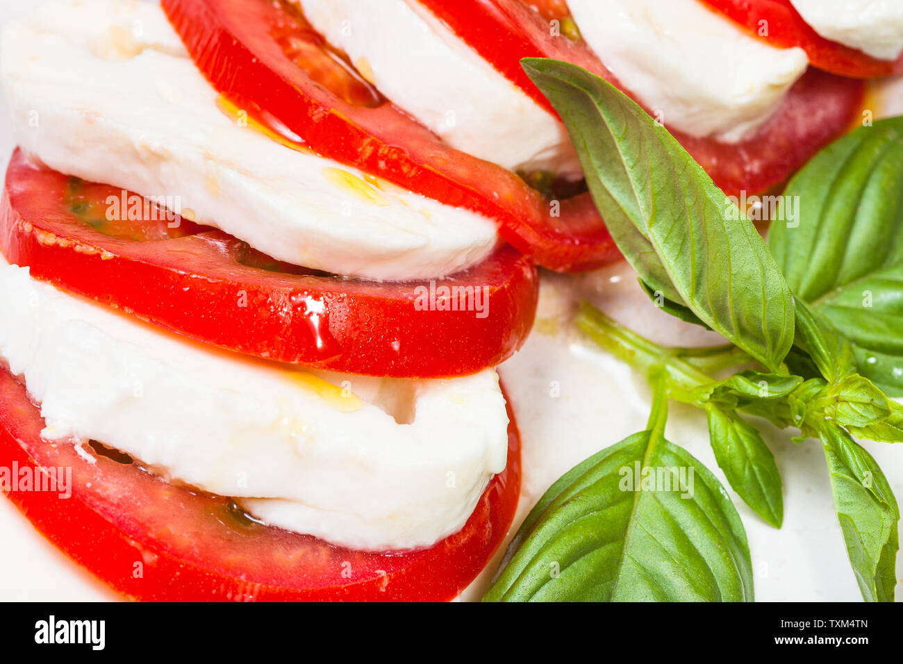 La cuisine italienne insalata caprese caprese (salade) - tranches de tomate et mozzarella au basilic twig close up Banque D'Images