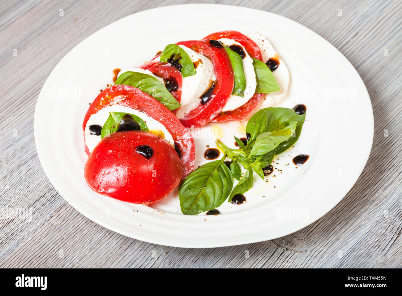 La cuisine italienne insalata caprese caprese (salade) - tranches de fromage mozzarella et de feuilles de basilic tomate assaisonné par l'huile d'olive et vinaigre balsamique sur Banque D'Images