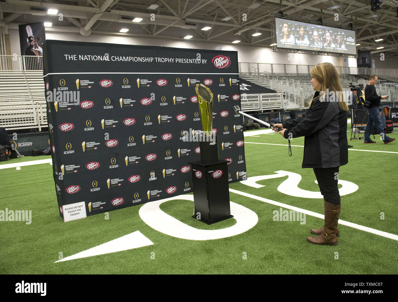 Vidéo d'une femme prend le trophée de championnat au cours de la journée des médias pour le Championnat national de football de la NCAA 2015, à Dallas, Texas, le 10 janvier 2015. Oregon s'affrontent contre l'Ohio State Buckeyes jeu dans le championnat national le lundi. Photo par Kevin Dietsch/UPI Banque D'Images