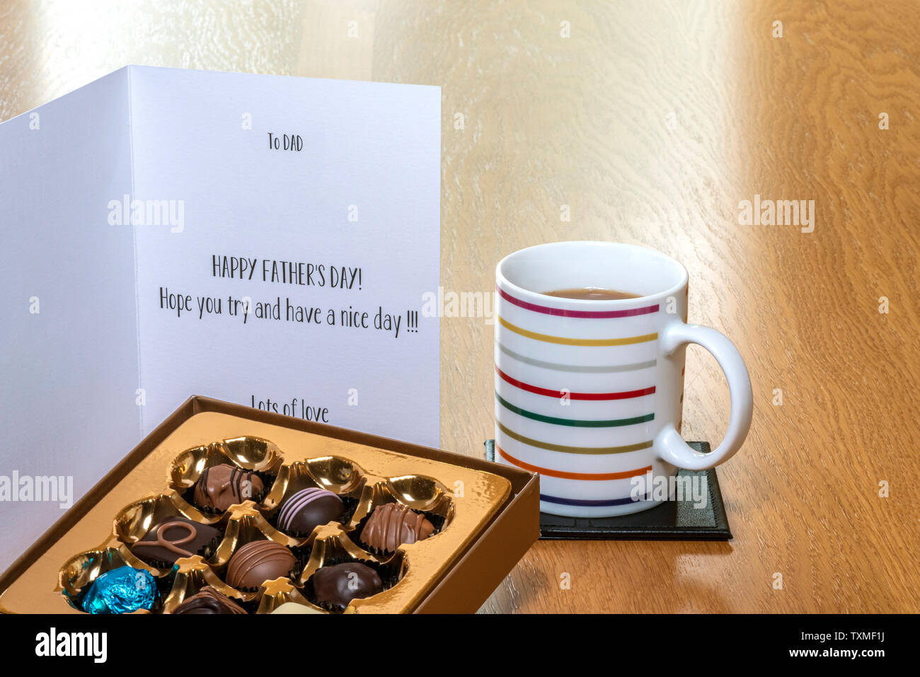 Fête des pères carte sur table en bois avec une boîte de chocolats, et une tasse de café ou de thé. Banque D'Images