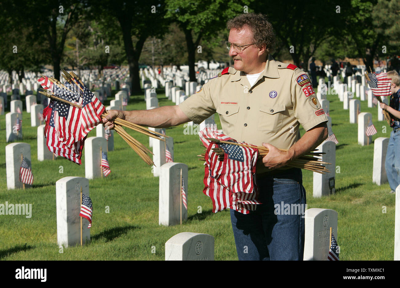 Chef Scout Bob Duggan porte une poignée de drapeaux américains au Fort Logan National Cemetery à Denver le 27 mai 2006. Boy-Scout et des groupes scouts louveteaux placé 87 000 Les drapeaux sur les tombes pour les célébrations du Jour du Souvenir. Cimetière national de Fort Logan a été créé en 1889 et a été nommé d'après le général John A. Logan, qui a émis l'Ordonnance générale no 11 qui a mis sur pied le 30 mai Jour de décoration qui plus tard est devenu une fête nationale appelée le jour du Souvenir. (Photo d'UPI/Gary C. Caskey) Banque D'Images
