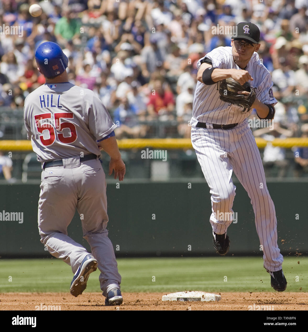 Rockies du Colorado Le deuxième but Clint Barmes (R) remplit un double jeu jeter sur Chicago Cubs catcher Koyle Hill pour mettre fin à la deuxième manche au Coors Field de Denver le 9 août 2009. Lou Piniella oursons manager a soutenu l'appel du juge-arbitre et a été éjecté. UPI/Gary C. Caskey... Banque D'Images