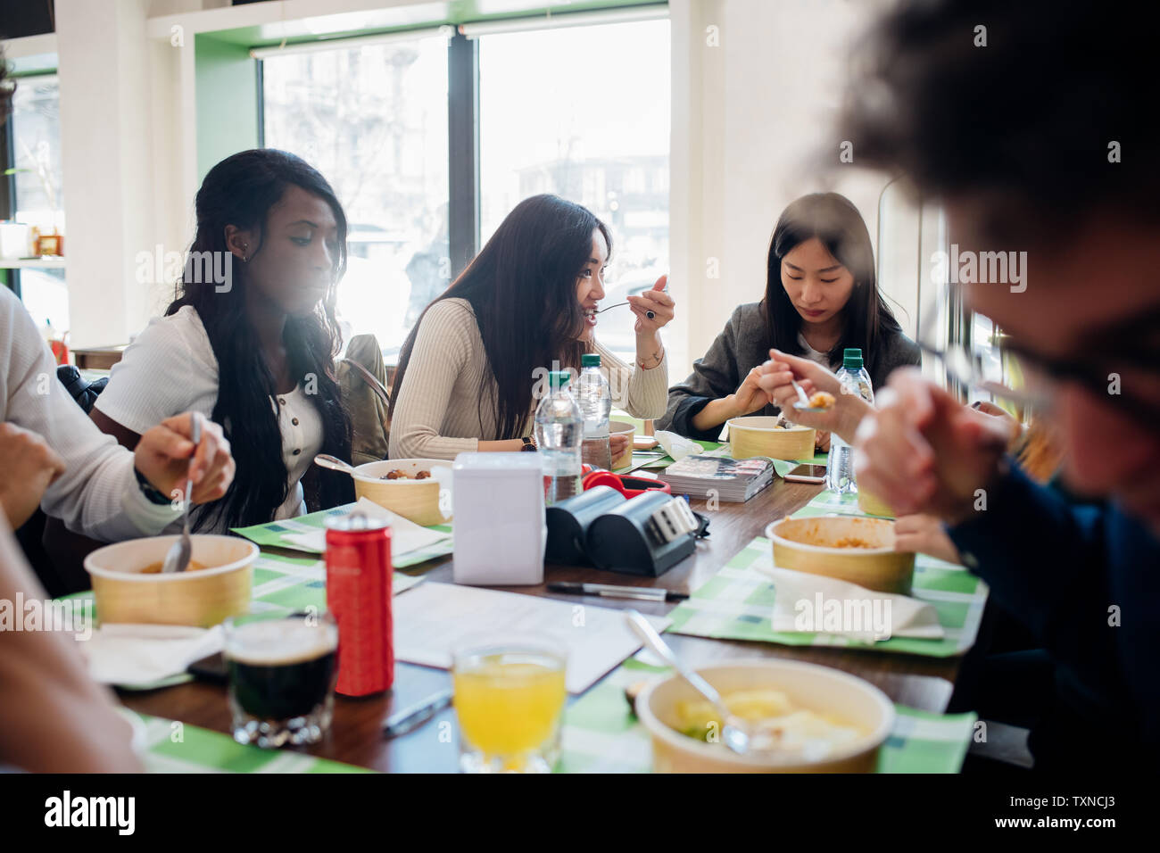 Les jeunes hommes et les femmes de l'équipe d'affaires déjeuner partage in cafe Banque D'Images