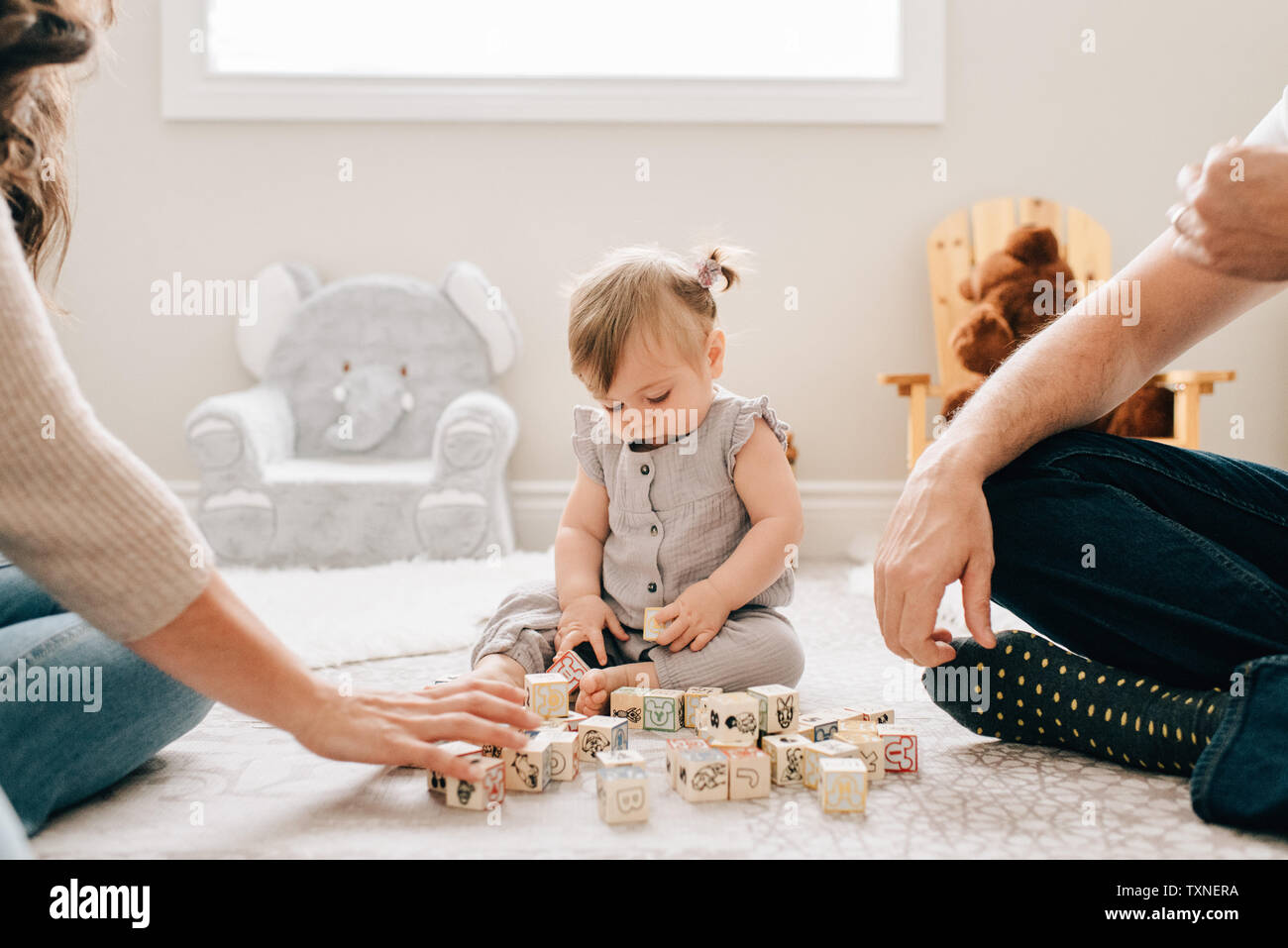 Mère et père sur les jardins d'étage avec petite fille jouant avec des blocs de construction, cropped Banque D'Images