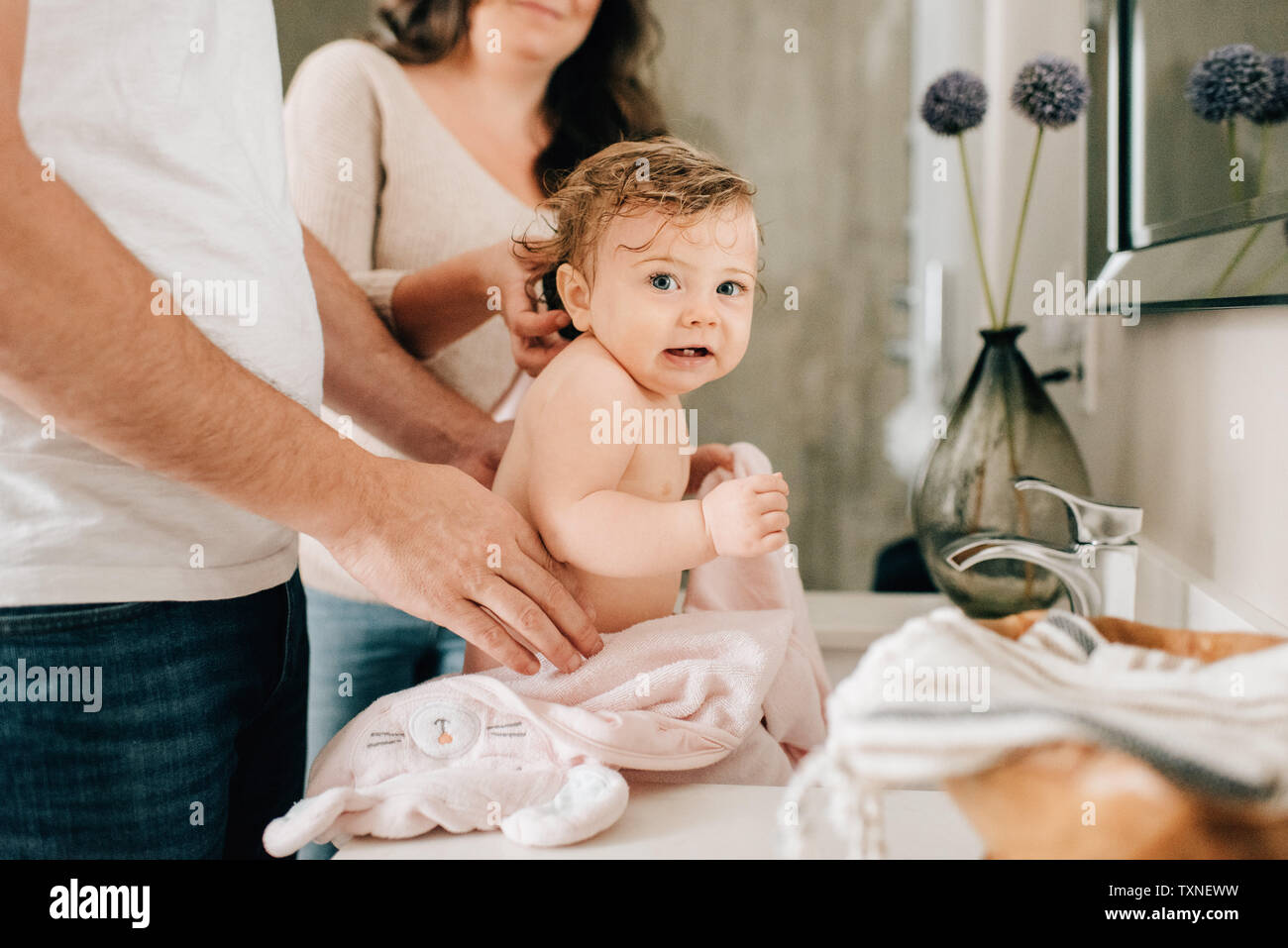 Mère et père fille bébé de séchage dans la salle de bains, cropped Banque D'Images