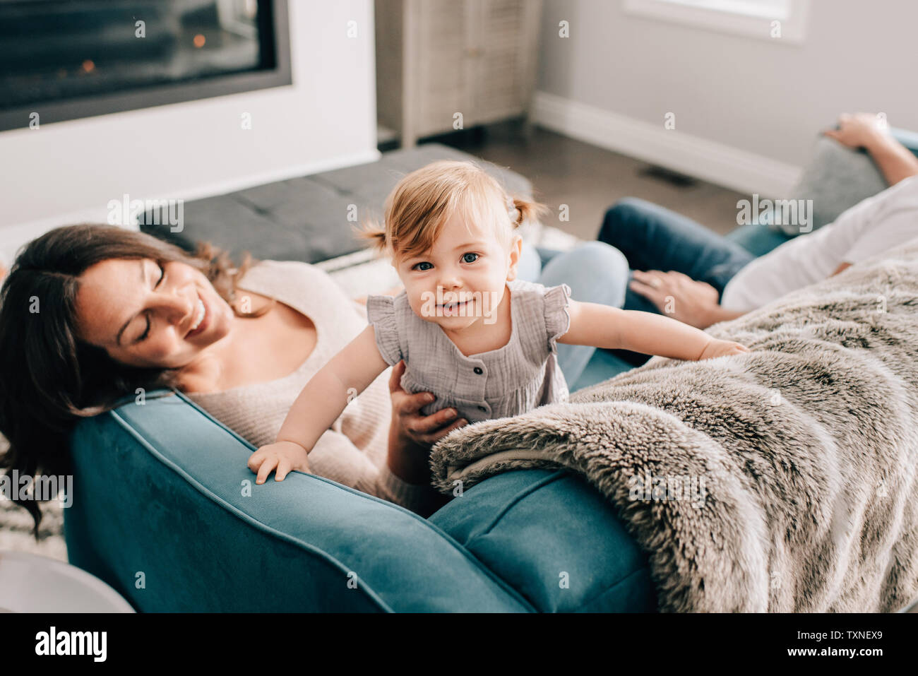 Mère jouant avec sa petite fille sur le canapé, portrait Banque D'Images