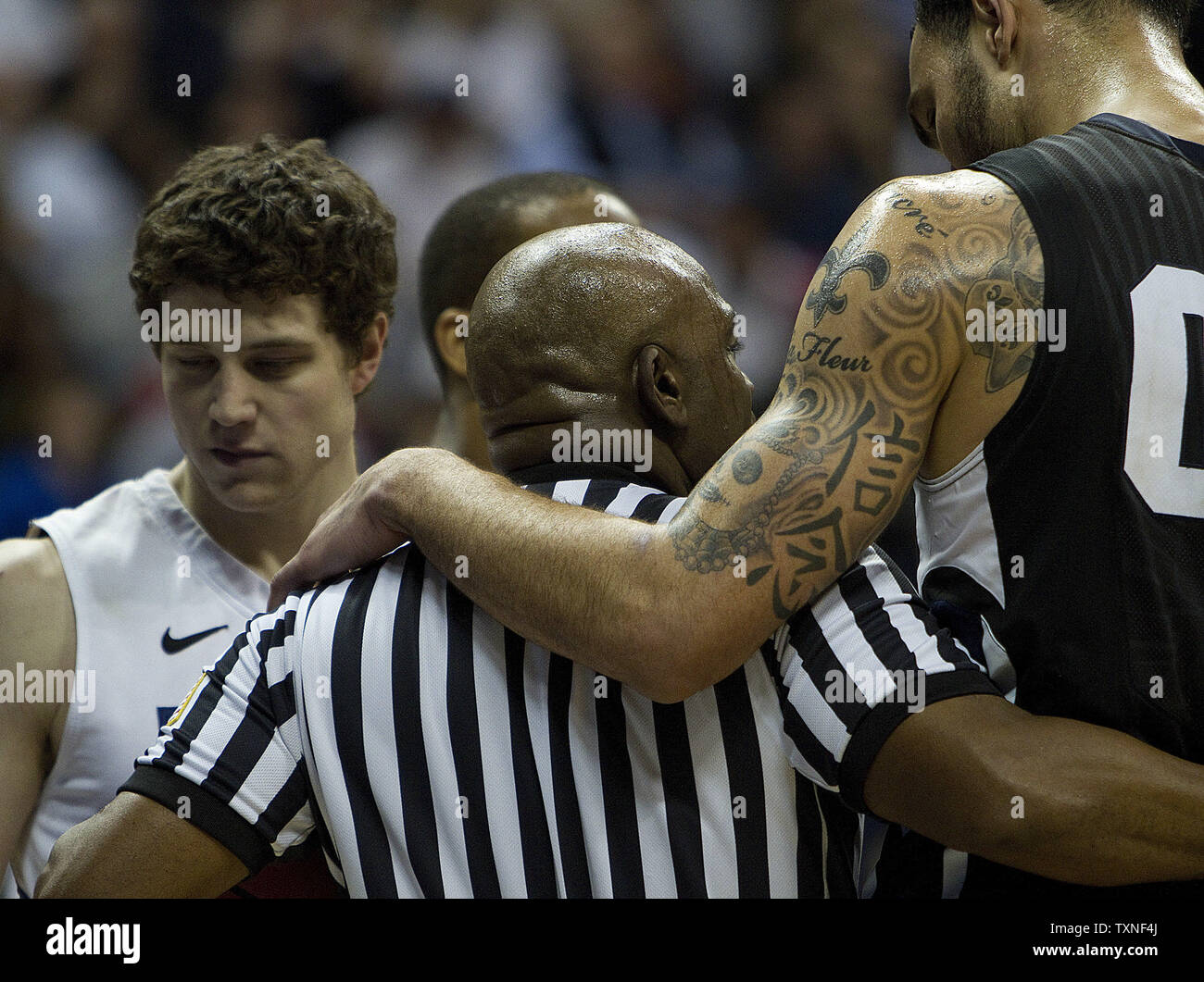 1568 Robert centre sacré (R) met son bras autour d'un arbitre après un appel fait en sa faveur contre BYU Jimmer Fredette star guard (L) au cours de la deuxième moitié de la NCAA du troisième tour à la régionale du Pepsi Center de Denver le 19 mars 2011. Les avances à la Brigham Young Sweet 16 battant Gonzaga 89-67 UPI/Gary C. Caskey Banque D'Images