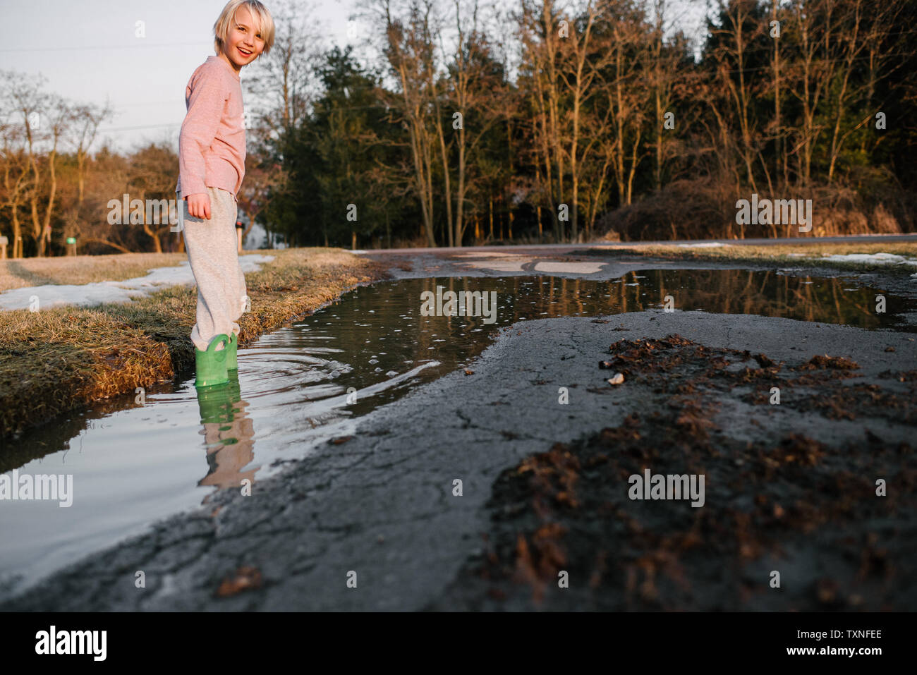 Garçon à la cheville en milieu rural flaque, portrait Banque D'Images