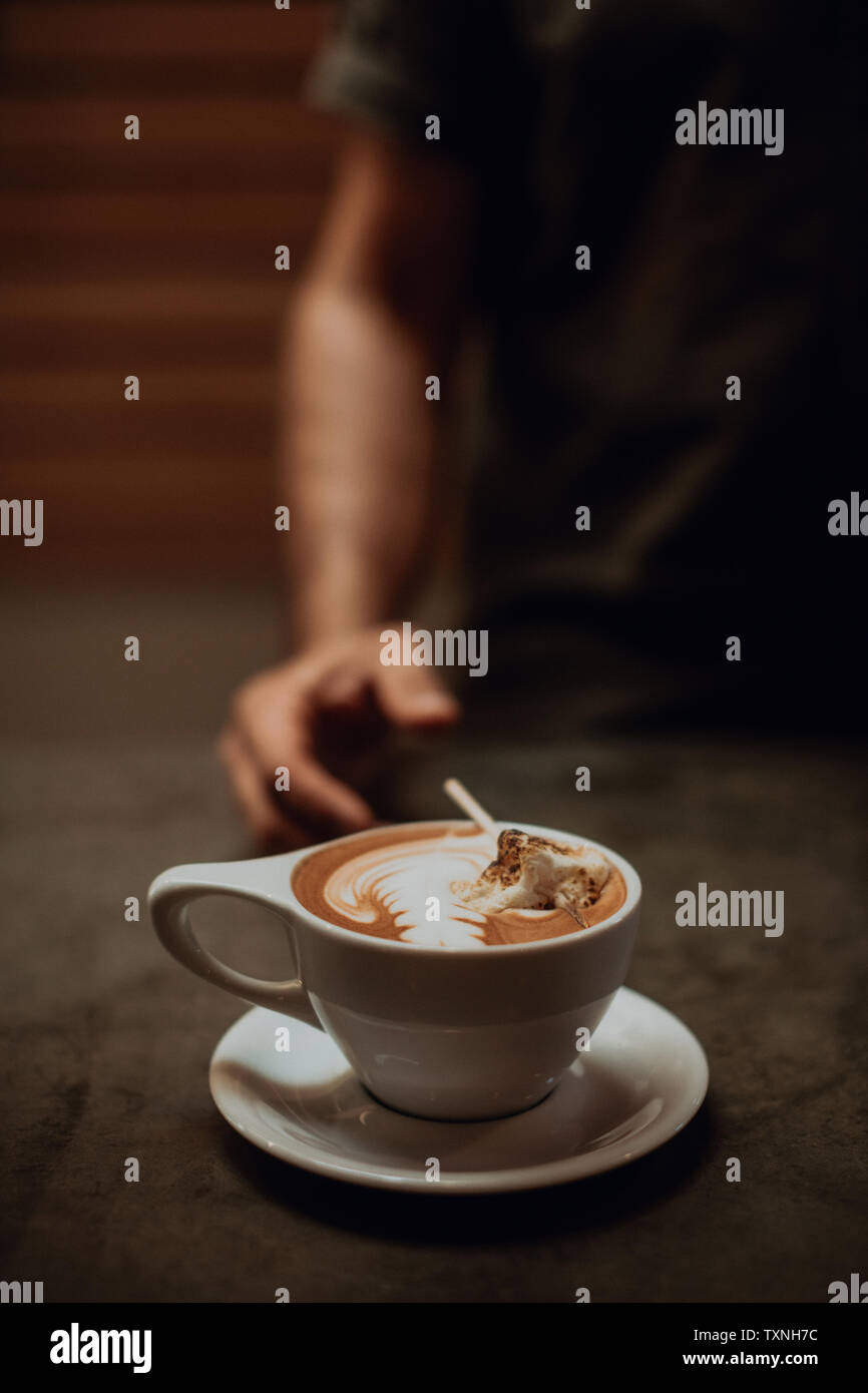 Au café barista compteur avec tasse de moka grillé garni de guimauve, l'accent peu profondes recadrée Banque D'Images