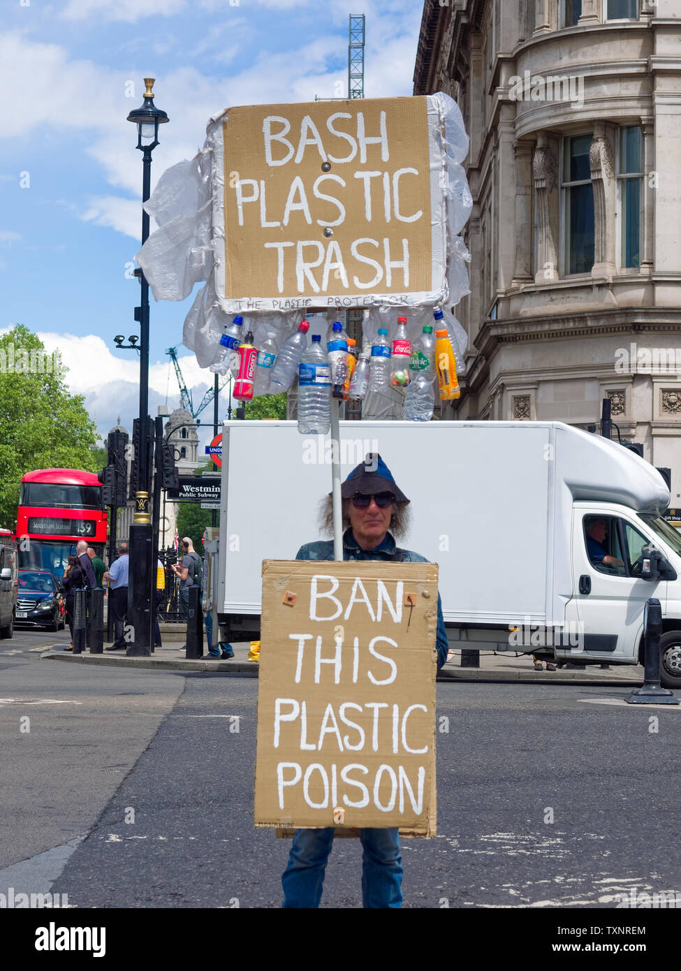 Personne debout sur la place du Parlement, Londres, Angleterre, Royaume-Uni, tenant des pancartes protestant contre le plastique à usage unique. Banque D'Images