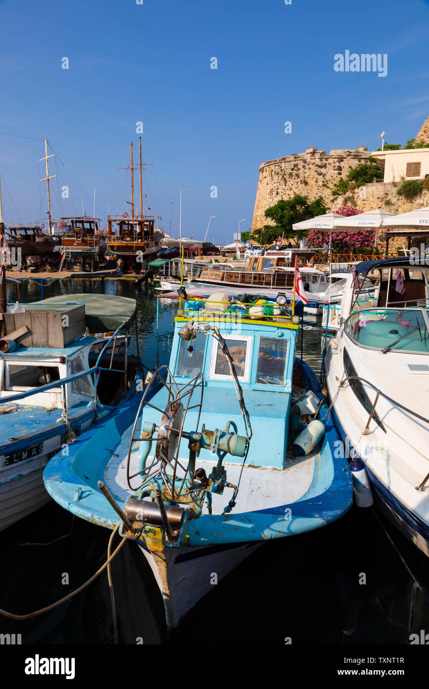 Les bateaux de pêche traditionnels chypriotes amarrée le long d'un bateau moderne, port et château de Kyrenia, Girne, République turque de Chypre du Nord. Banque D'Images