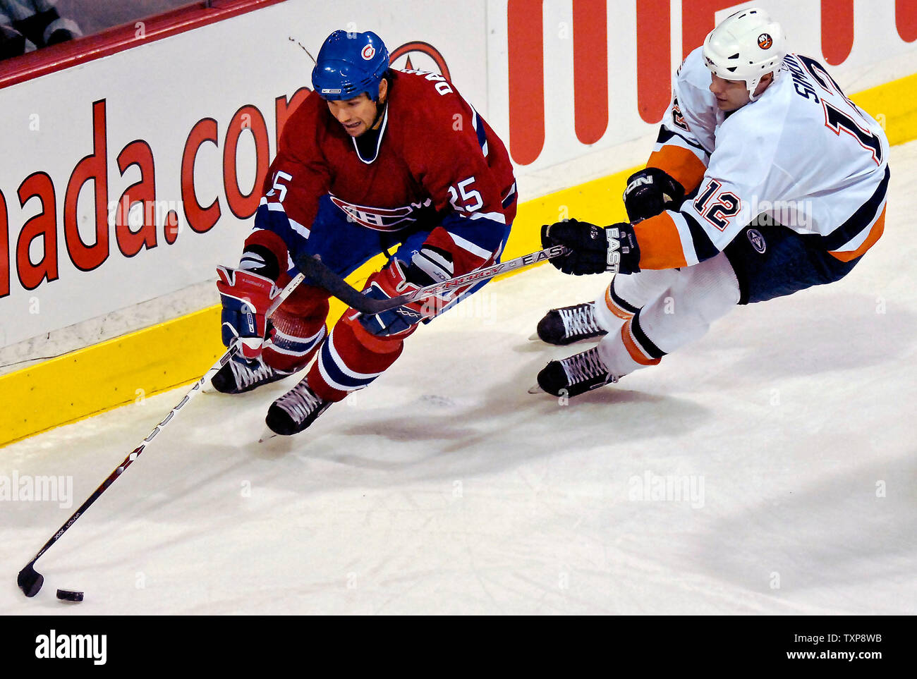 Le défenseur des Canadiens de Montréal Mathieu Dandenault (25) maintient le palet loin des Islanders de New York avant de l'aile gauche Chris Simon (12) dans la deuxième période au Centre Bell à Montréal, Canada le 3 février 2007. Les Islanders a vaincu les Canadiens 4-2. (Photo d'UPI/Ed Wolfstein) Banque D'Images