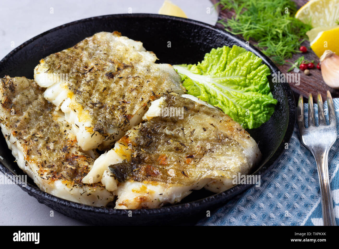 Morue frite filet de poisson aux épices dans une poêle en fonte Banque D'Images