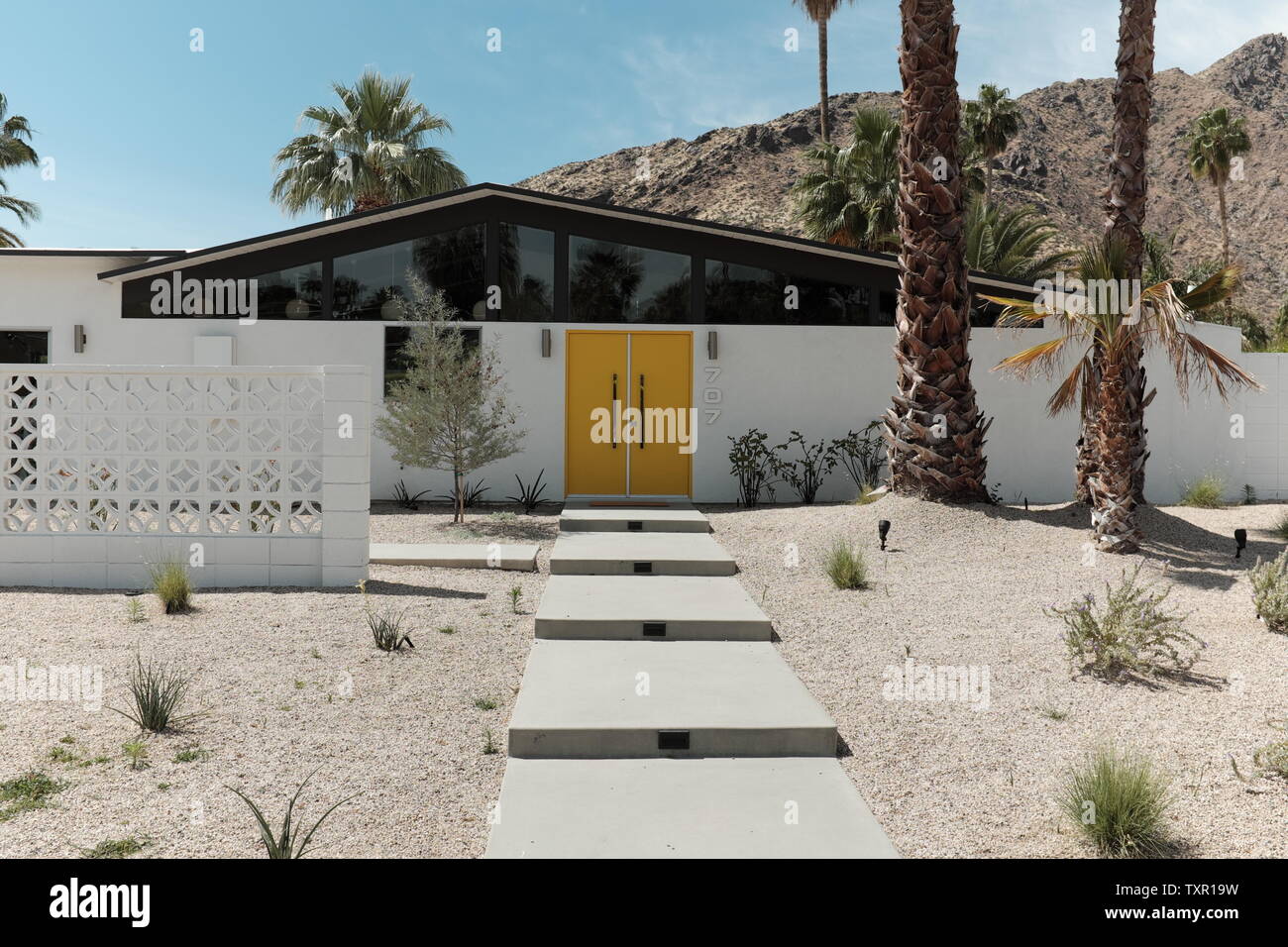 Maison moderniste de milieu de siècle conçue avec des portes jaunes et des blocs de brise dans une maison de désert à Palm Springs, Californie, États-Unis. Banque D'Images