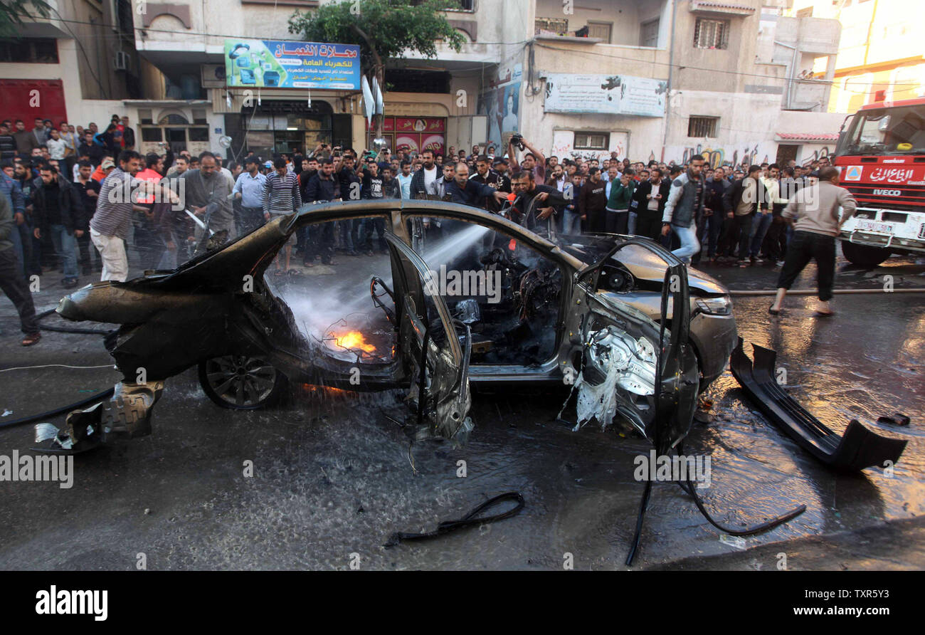 Palestinien Occupé - éteindre l'incendie Les pompiers palestiniens à partir de la voiture de Ahmad Jaabari, chef de la branche militaire du Hamas, les Brigades Ezzedin Qassam, après qu'il a été touché par une frappe aérienne israélienne à Gaza le 14 novembre 2012 Israël a tué le chef militaire du groupe islamiste du Hamas dans un missile sur la bande de Gaza le mercredi et a lancé des raids aériens à travers l'enclave, poussant les deux côtés à la veille d'une nouvelle guerre. Le Hamas a déclaré Ahmed Al-Jaabari, qui dirigeait la branche armée de l'organisation, Izz el-Deen Al-Qassam, est mort avec un associé sans nom quand leur voiture Banque D'Images