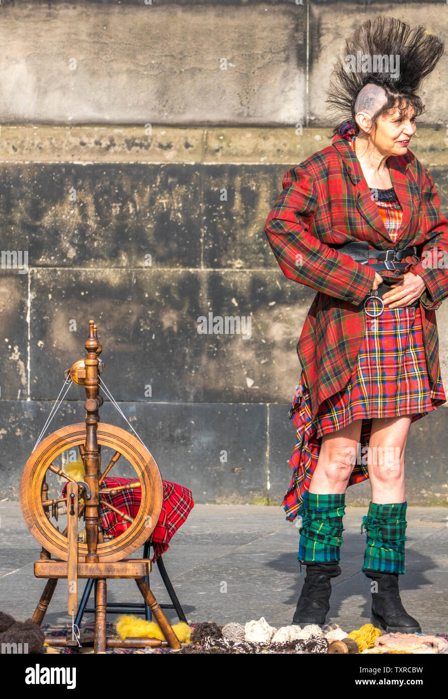 Royal Mile d'édimbourg attractions touristiques - une femme plus âgée avec des cheveux hérissés et tartan outfit, debout sur une machine à filer la laine traditionnelle. Banque D'Images
