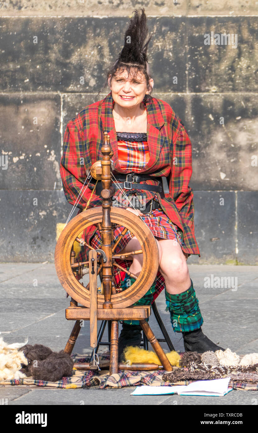 Royal Mile d'édimbourg attractions touristiques - une femme plus âgée avec des cheveux hérissés et tartan outfit, assis à une machine à filer la laine traditionnelle. Banque D'Images
