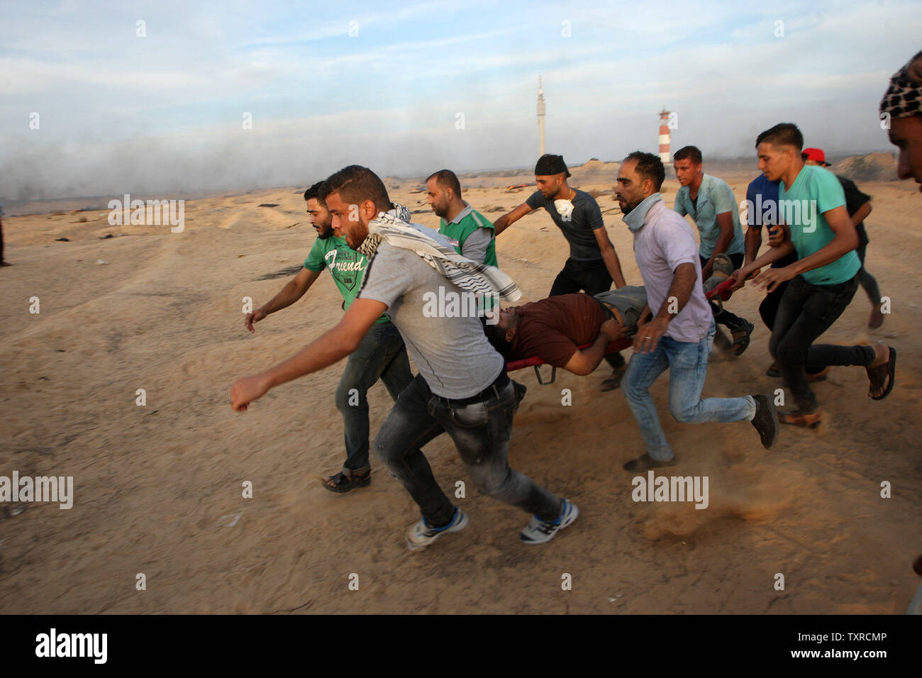 Les manifestants portent un manifestant palestinien blessé lors d'affrontements près de Rafah, dans le sud de la bande de Gaza le long de la frontière Gaza-Israel, dans la bande de Gaza, le 5 octobre 2018. Deux Palestiniens étaient tués et des dizaines de blessés, une source médicale a dit à la 18e semaine de protestations permanentes. Photo par Ismael Mohamad/UPI Banque D'Images