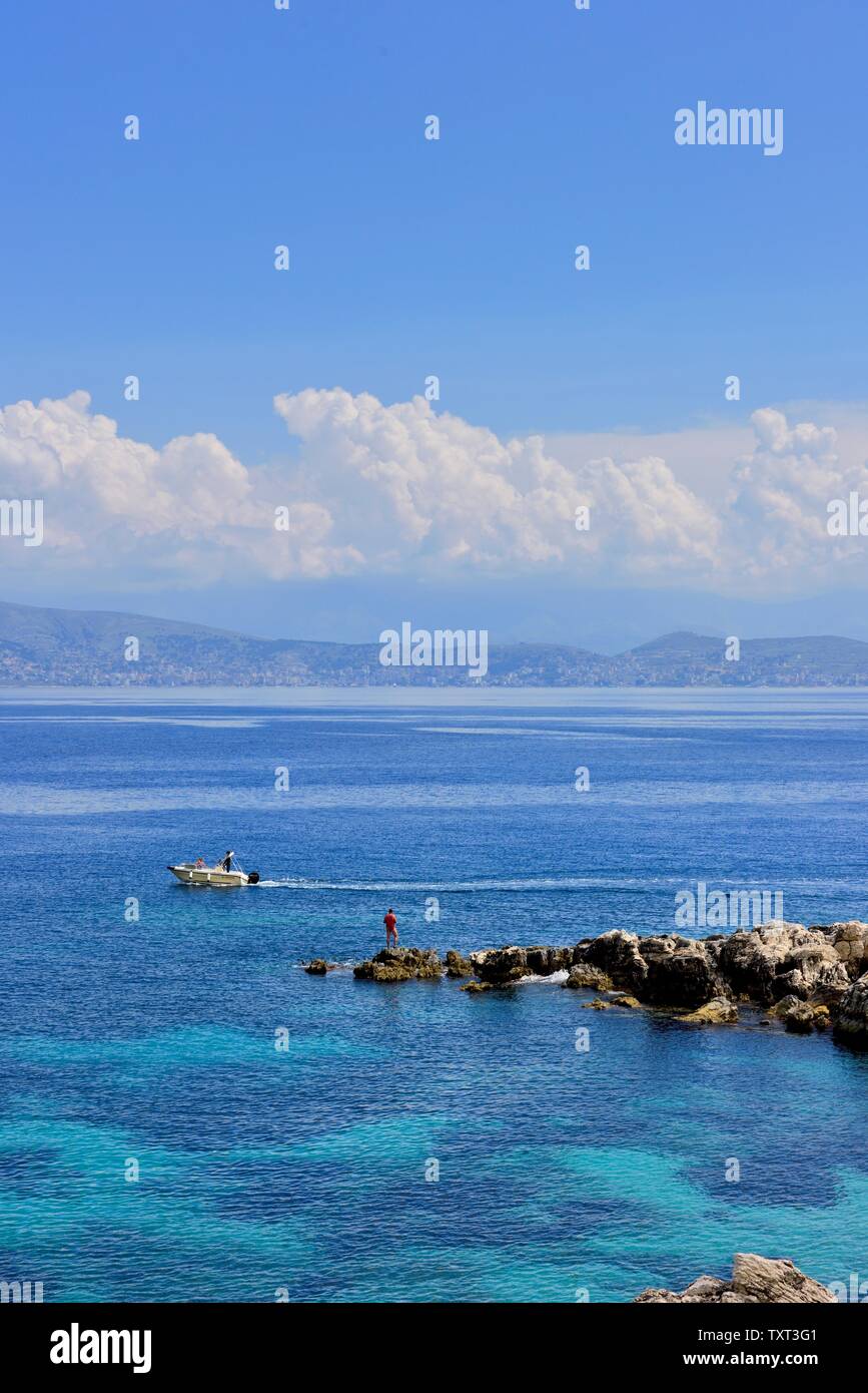 Un homme de pêche quelques roches à Kassiopi,Kassopaia,Îles Ioniennes, Corfou, Grèce Banque D'Images