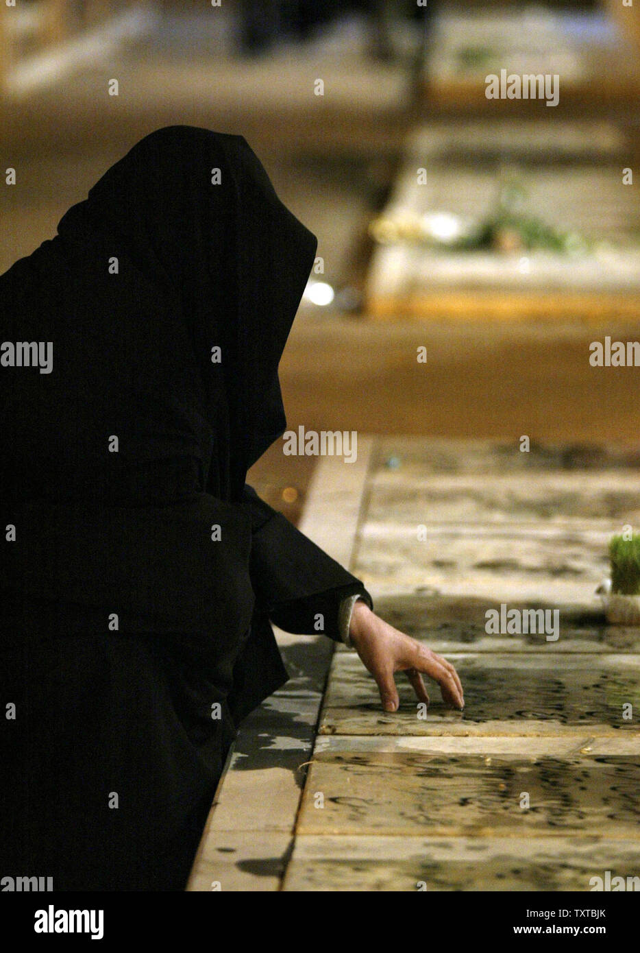 Une femme iranienne prie près de leurs martyrs cimetière le Nouvel an Iranien 'Norooz' dans Qazvin, 83 milles (150 Km) de Téhéran, Iran le 21 mars 2006. Norooz est le début du printemps astronomique, ou Équinoxe de printemps, cette année le 20 mars. Les Iraniens passent la semaine avant Norooz en préparation pour les vacances.(Photo UPI/Mohammad Kheirkhah) Banque D'Images