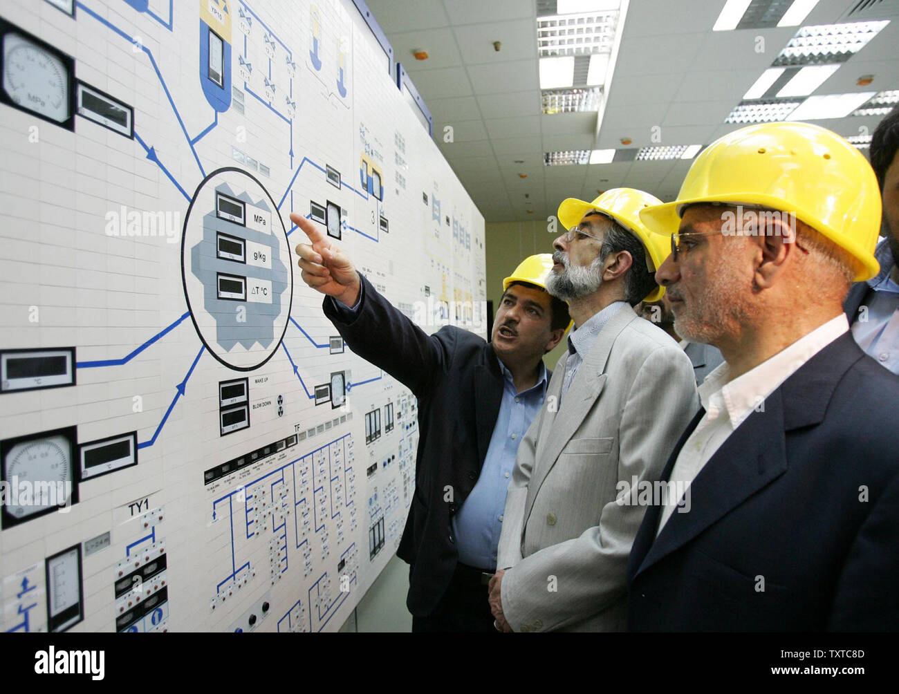 Le Parlement de l'Iran Le Président Gholamali Haddad Adel (C) et Gholamreza Aghazadeh le chef de l'Organisation de l'énergie atomique de l'Iran (R) d'assister en tant qu'un des membres du personnel de l'Organisation de l'énergie nucléaire iranien explique le processus de construction d'elles pendant leur visite la construction de la centrale nucléaire de Bushehr près du golfe Persique, 1 000 km au sud de Téhéran, Iran , June 27,2006. (Photo/UPI/Kholousi Amir Agence de presse des étudiants iraniens) Banque D'Images