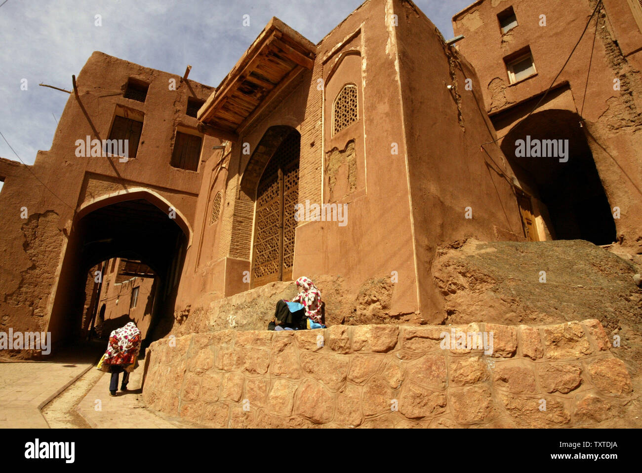 Une femme iranienne repose comme une autre femme passe devant elle à Abyaneh village près de la ville de Kashan à Ispahan Province 232,5 milles (375 km) au sud-est de Téhéran le 8 mars 2007. Le village est l'une des plus anciennes de l'Iran, attirant de nombreux touristes étrangers et indigènes à l'année, et a été qualifié d'entrée de l'histoire de l'Iran. UPI (photo) Banque D'Images