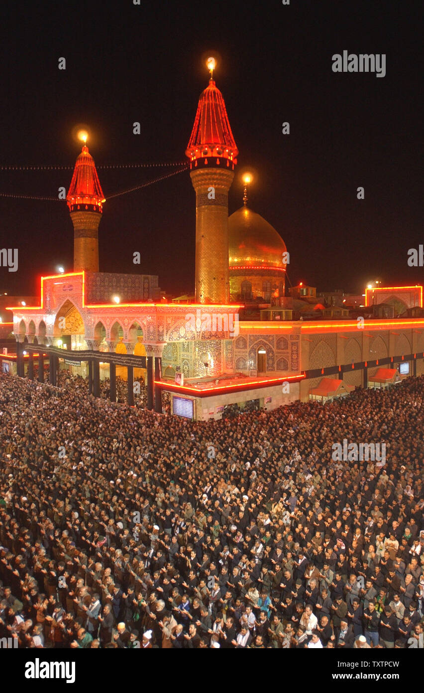 Fidèles prient en face de l'Iman Hussein de culte pendant la fête musulmane de l'Ashoura chiite dans la ville sainte de Kerbala, l'Iraq le 1 mars 2004. La sécurité est précaire dans la ville comme des dizaines de milliers de pèlerins venus assister à la fête qui commémore la mort de Hussein, petit-fils de Mohammed au 7ème siècle. Le festival se termine le 2 mars 2004. (Photo d'UPI/Ali Khaligh) Banque D'Images