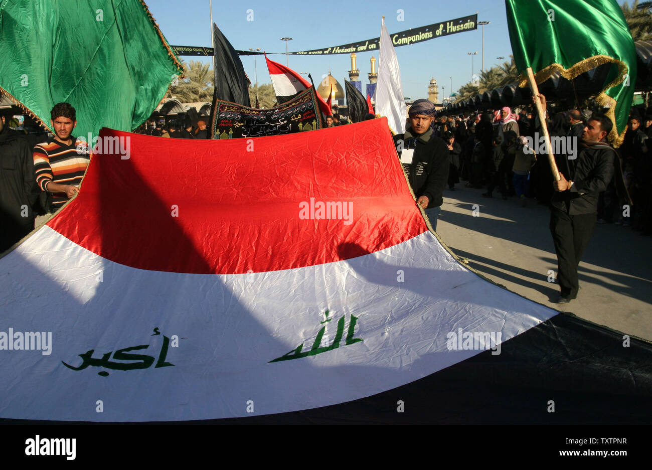 Les pèlerins portent un drapeau irakien en dehors du sanctuaire de l'Imam Hussein, lors d'une cérémonie funéraire Ashura à Karbala, en Irak le 5 janvier 2009. Des centaines de milliers de Chiites se rendra dans la ville sainte de Kerbala tout au long de l'Ashoura semaine pour marquer le décès de l'Imam Hussein, le petit-fils du prophète Mohammad. (Photo d'UPI/Ali Jasim) Banque D'Images