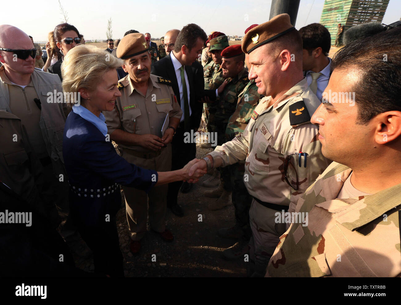 Le ministre allemand de la défense, Ursula von der Leyen (L), serre la main avec un agent des peshmergas kurdes près d'Arbil, la capitale de la région autonome kurde dans le nord de l'Iraq, le 25 septembre 2014. Von der Leyen a fait un voyage à l'improviste à l'Iraq et a assuré kurdes dans le Nord de la solidarité durable pour leur lutte contre l'Etat islamique (ISIS). UPI/Ayad Rasheed Banque D'Images