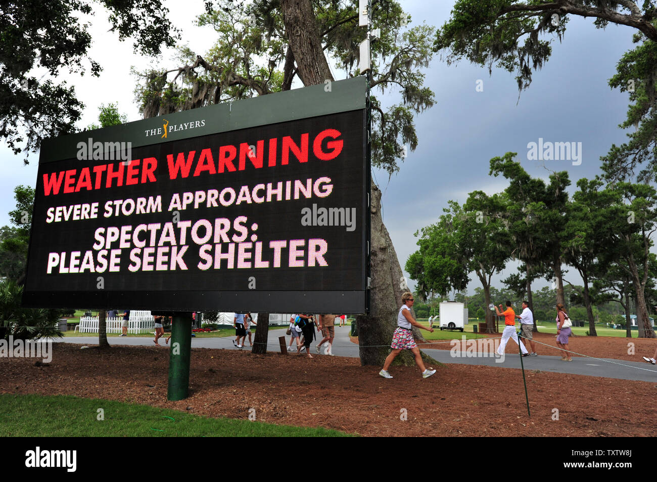 Un panneau d'affichage derrière la 9ème clignote vert une alerte météorologique comme spectateurs à pied le long d'une allée au cours de la troisième série de Championnat des Joueurs Le samedi 14 mai 2011 sur le stade au cours TPC Sawgrass à Ponte Vedra Beach, en Floride. Photo UPI/Rick Wilson Banque D'Images