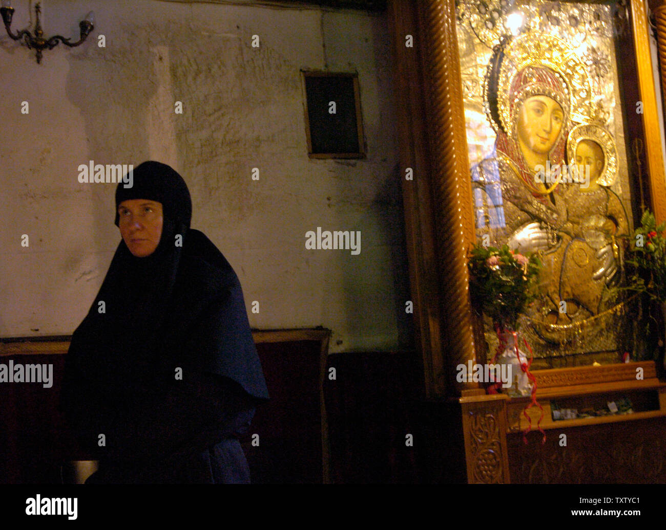 Une religieuse prie à côté d'une icône de la Vierge à l'enfant dans l'église de la Nativité, le site où la tradition croit que Jésus est né à Bethléem, en Cisjordanie, le 12 décembre 2004. Les ministres du tourisme israélien et palestinien ont signé un accord de reprise de la coopération pour amener les touristes à Bethléem pour Noël après quatre ans de conflit et de violence qui a ravagé le tourisme dans la ville biblique. (Photo d'UPI/Debbie Hill) Banque D'Images