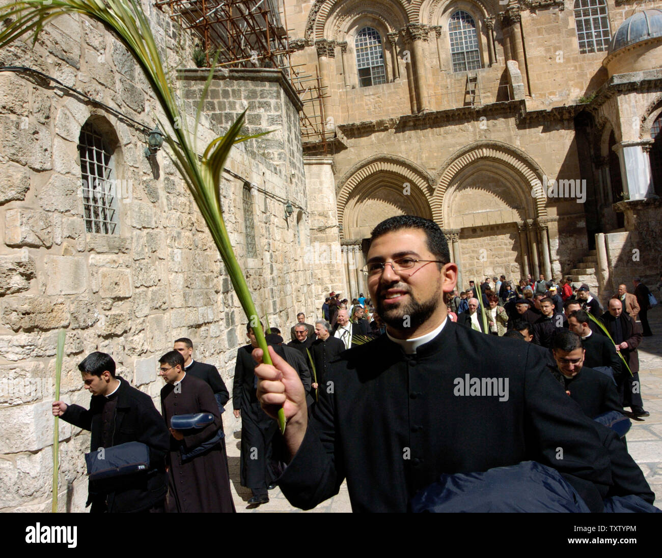 Un prêtre porte un palm brach le Dimanche des Rameaux à l'extérieur de l'église du Saint-Sépulcre dans la vieille ville de Jérusalem, le 20 mars 2005. (Photo d'UPI/Debbie Hill) Banque D'Images