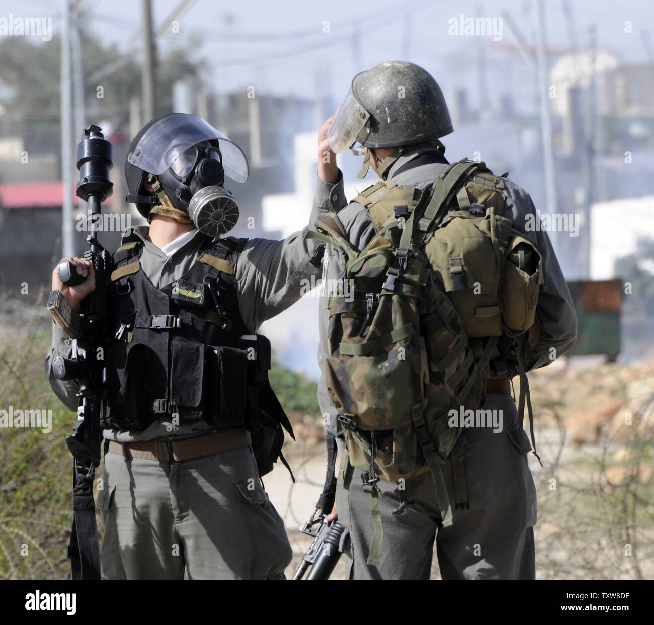 Une police des frontières israélienne porte un gasmask après avoir tiré des gaz lacrymogènes sur des manifestants palestiniens, pas connu, dans le village en Nabi Salih, le 12 février 2010. Les Palestiniens disent que la colonie israélienne Halamish prend leurs terres et l'eau. UPI/Debbie Hill Banque D'Images