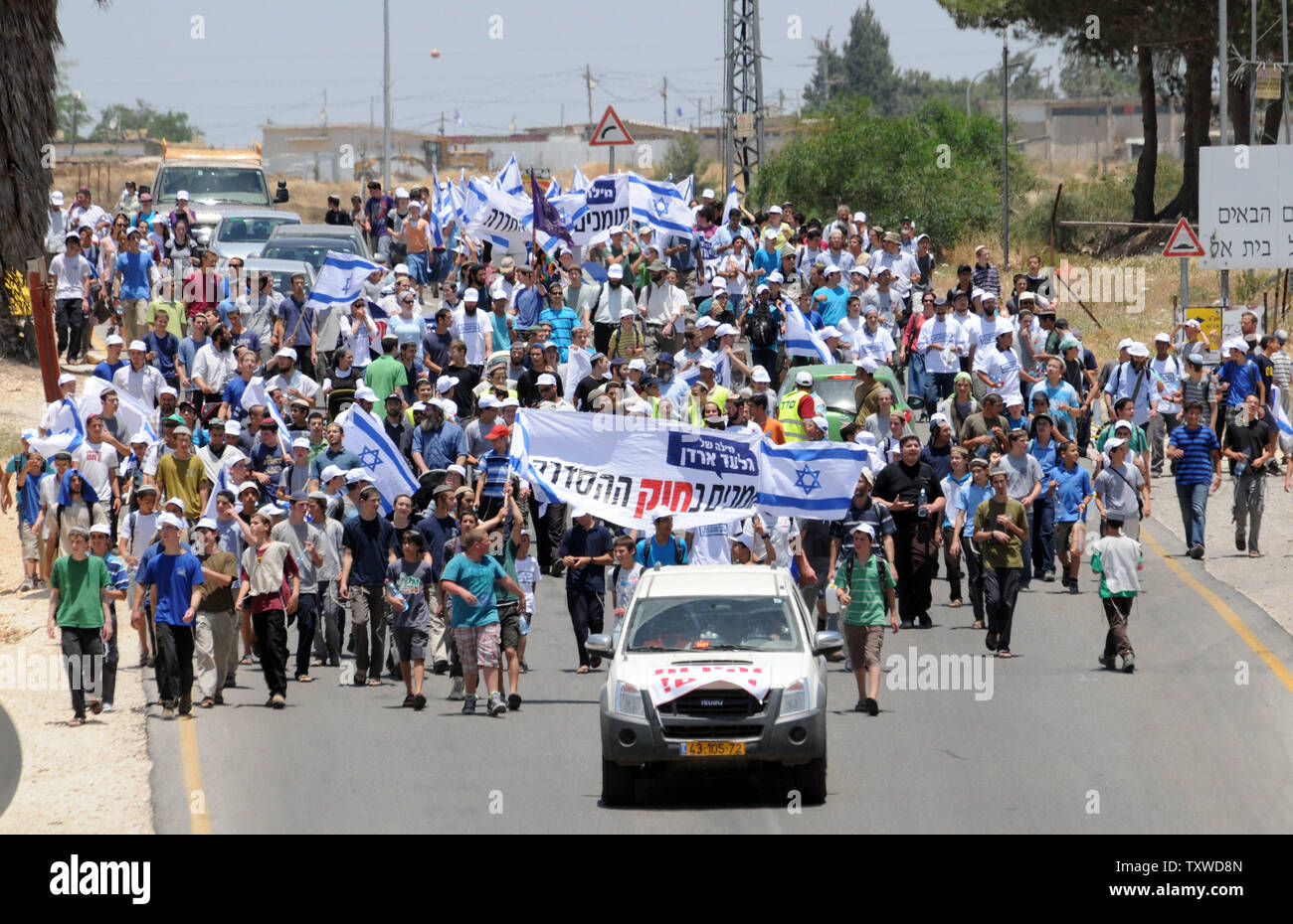 Vague de colons israéliens le drapeau national dans la colonie de Beit El pendant une marche de protestation de l'Ulpana settlement outpost de Cisjordanie à Jérusalem, le 4 juin 2012. Les colons manifestent contre le Premier ministre israélien Benjamin Netanyahu's intention de réinstaller des cinq maisons construites sur des terres appartenant à des Palestiniens à la suite d'une commande par la Cour suprême israélienne. UPI/Debbie Hill Banque D'Images