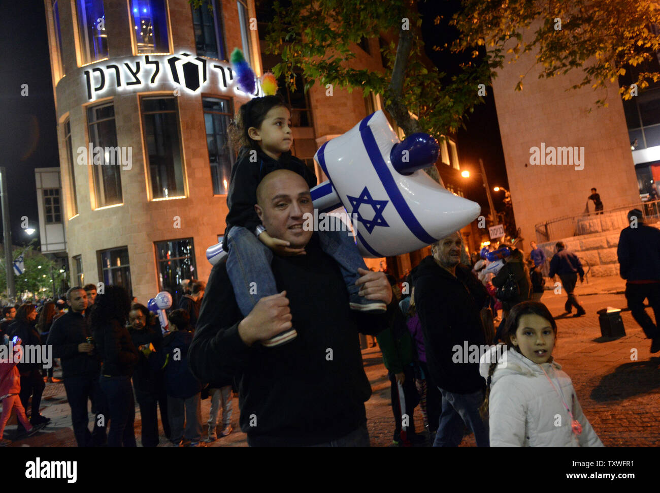Un Israélien porte sa fille avec un grand coup de marteau, le drapeau national lors de commémorations de l'indépendance à Jérusalem, Israël, le 15 avril 2013. Israël est marquant 65 ans depuis la création de l'état juif en 1948. UPI/Debbie Hill Banque D'Images