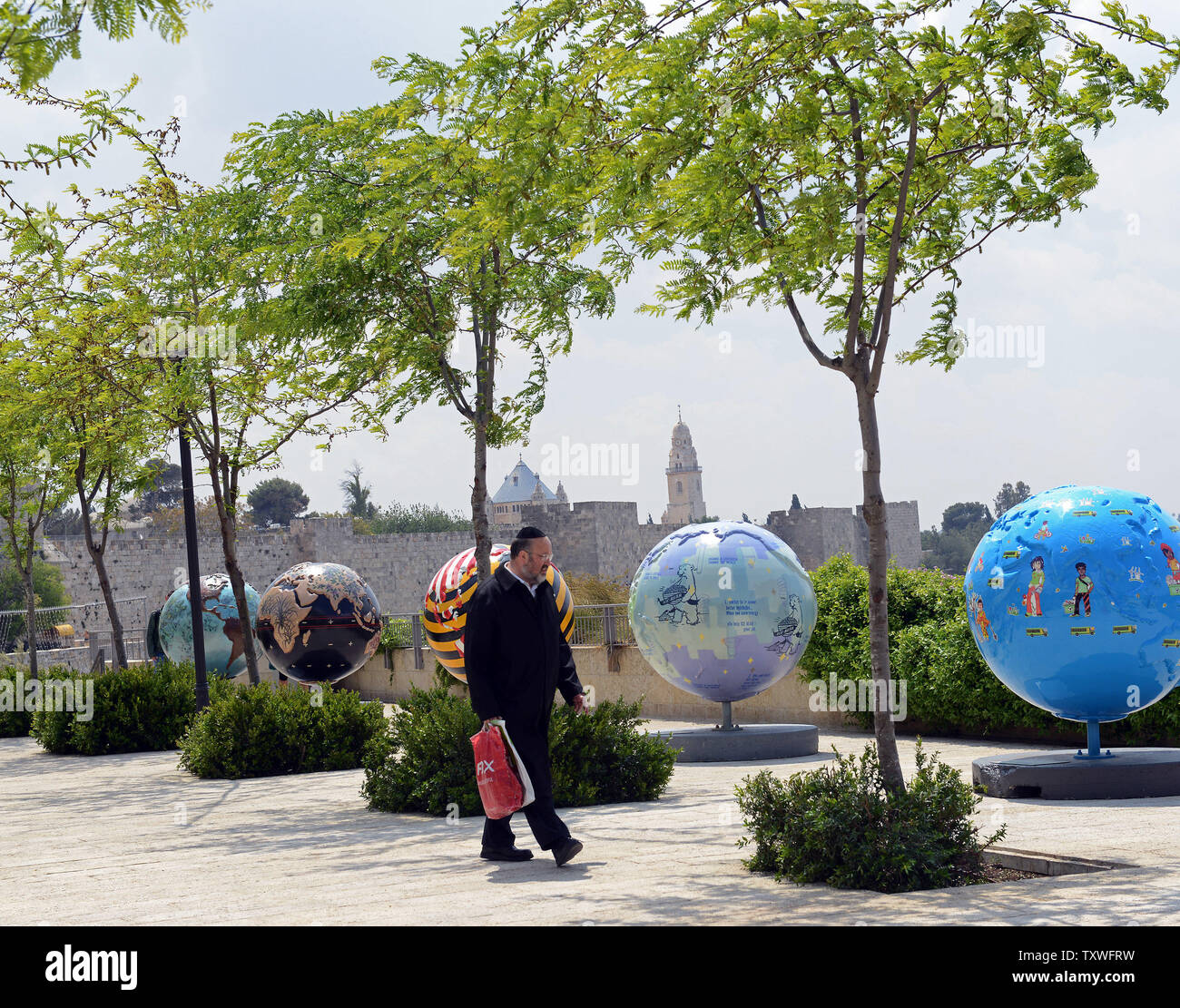 Une Israélienne orthodoxe passe devant les Cool Globes Project, une exposition d'art publique internationale 18 globes surdimensionné conçu pour inspirer un appel à l'action environnementale, près de la porte de Jaffa, l'extérieur de la vieille ville de Jérusalem, Israël, le 19 avril 2013. Les globes, une initiative de l'organisme sans but lucratif basé à Chicago Cool Globes, vise à faire prendre conscience des changements climatiques. Les globes ont été portées à Jérusalem dans le cadre du premier Symposium international de Jérusalem sur vert et accessible qui a lieu de pèlerinage à Jérusalem cette semaine. UPI/Debbie Hill Banque D'Images