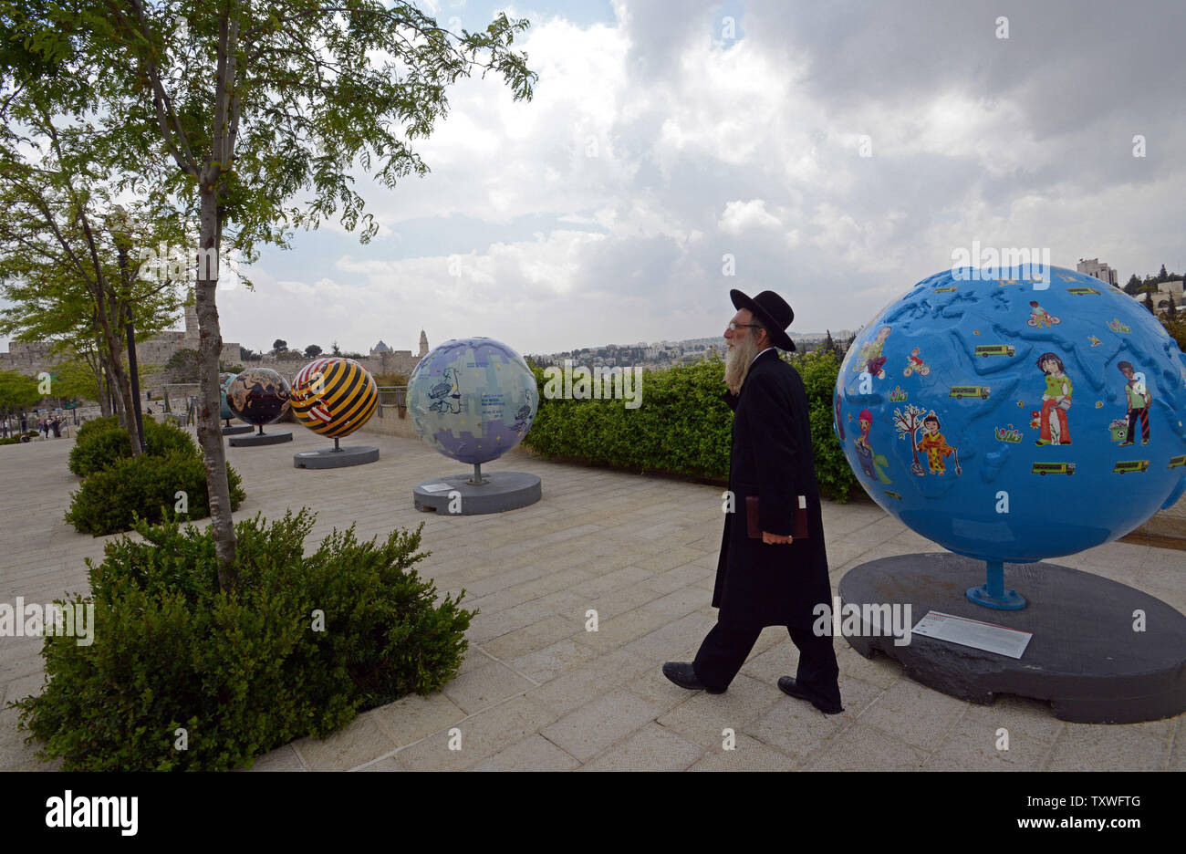 Un Israélien ultra-orthodoxes passe devant les Cool Globes Project, une exposition d'art publique internationale 18 globes surdimensionné conçu pour inspirer un appel à l'action environnementale, près de la porte de Jaffa, l'extérieur de la vieille ville de Jérusalem, Israël, le 19 avril 2013. Les globes, une initiative de l'organisme sans but lucratif basé à Chicago Cool Globes, vise à faire prendre conscience des changements climatiques. Les globes ont été portées à Jérusalem dans le cadre du premier Symposium international de Jérusalem sur vert et accessible qui a lieu de pèlerinage à Jérusalem cette semaine. UPI/Debbie Hill Banque D'Images