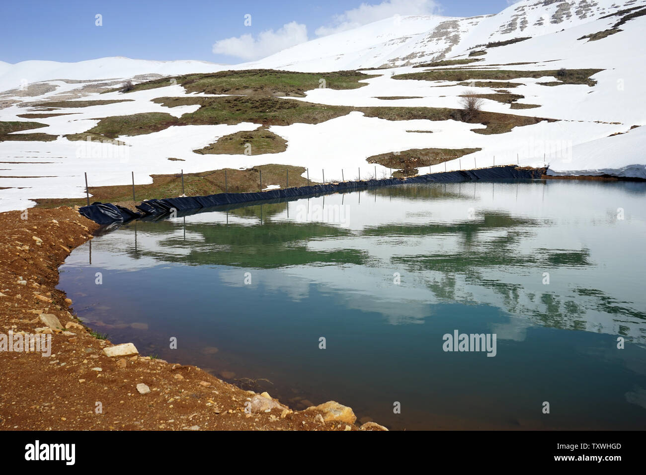 Étang avec de l'eau et la neige montagne près de Quadisha valley au Liban Banque D'Images
