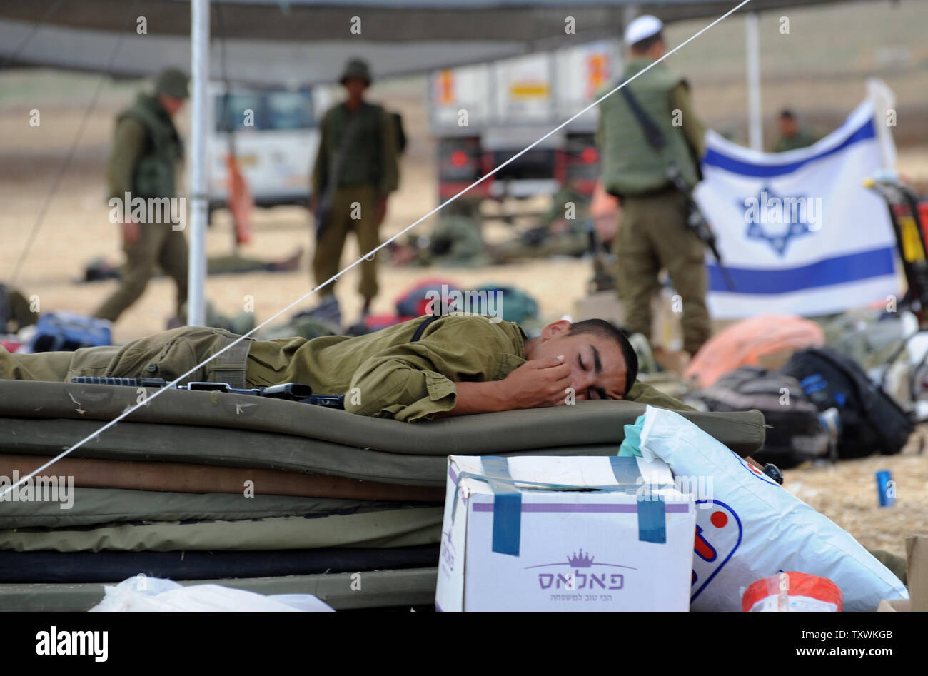 Un soldat israélien dort à une zone de préparation à un emplacement près de la frontière israélienne avec la bande de Gaza dans le sud d'Israël, le 28 juillet 2014. Les combats entre Israël et le Hamas a été plus calme au premier jour de la fête musulmane de l'Aïd Al Fitr, après la pression exercée par le Conseil de sécurité de l'ONU et le Président Barak Obama pour un cessez-le-feu immédiat. UPI/Debbie Hill Banque D'Images