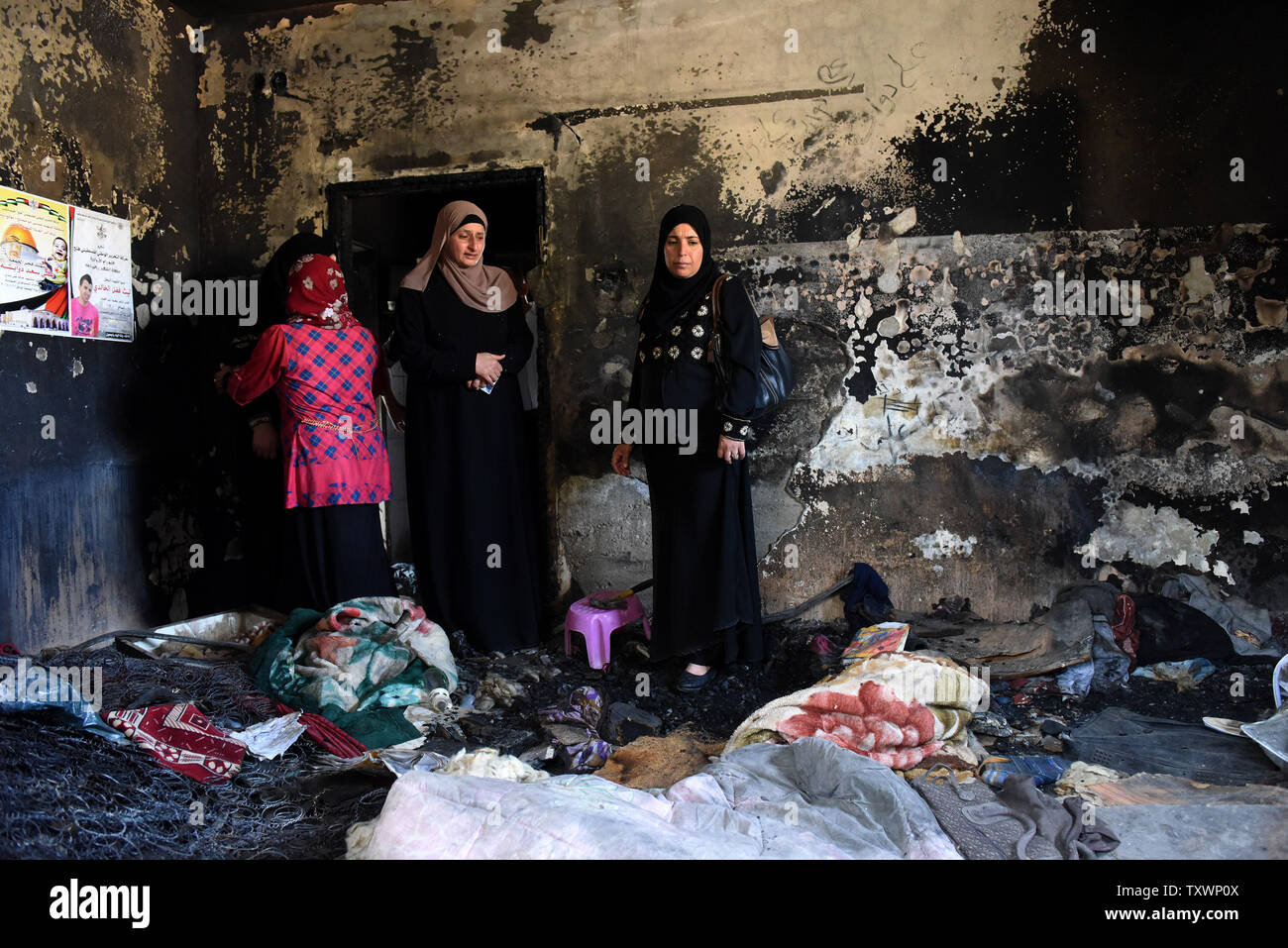 Palestiniens visiter la chambre de combustion une maison qui a été incendiée par des extrémistes juifs de droite dans une "étiquette de prix" la semaine dernière qui a brûlé à mort Ali Dawabsheh, un bébé palestinien de dix-huit mois et gravement blessé ses parents et quatre ans en frère Douma, Cisjordanie, le 6 août 2015. Le cabinet de sécurité israélien a adopté une mesure visant à permettre aux forces de l'ordre d'arrêter les citoyens Israéliens soupçonnés d'actes de terrorisme sans procès et l'accès à l'assistance juridique, qui n'a été utilisé qu'avec les Palestiniens. Quatre israéliens ont été arrêtés et sont détenus dans administrati Banque D'Images