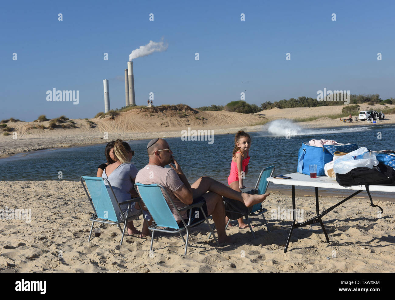 Centrale électrique d'Israël est vu dans la distance à Ashkelon, que d'Israéliens profiter de la plage sur la Mer Méditerranée près du kibboutz Zikim, sur la frontière, Israeli-Gaza 22 Juin, 2017. Cette semaine nationale de l'Israélien Electric Company Limited c'est couper l'approvisionnement en électricité de la bande de Gaza après l'Autorité palestinienne a refusé de payer les factures d'électricité du Hamas. Le mercredi, l'Egypte a fourni 1,1 millions de litres de carburant diesel pour Gaza, qui devrait durer quatre jours, tournant à 50  % c'est la capacité. Photo par Debbie Hill/UPI Banque D'Images