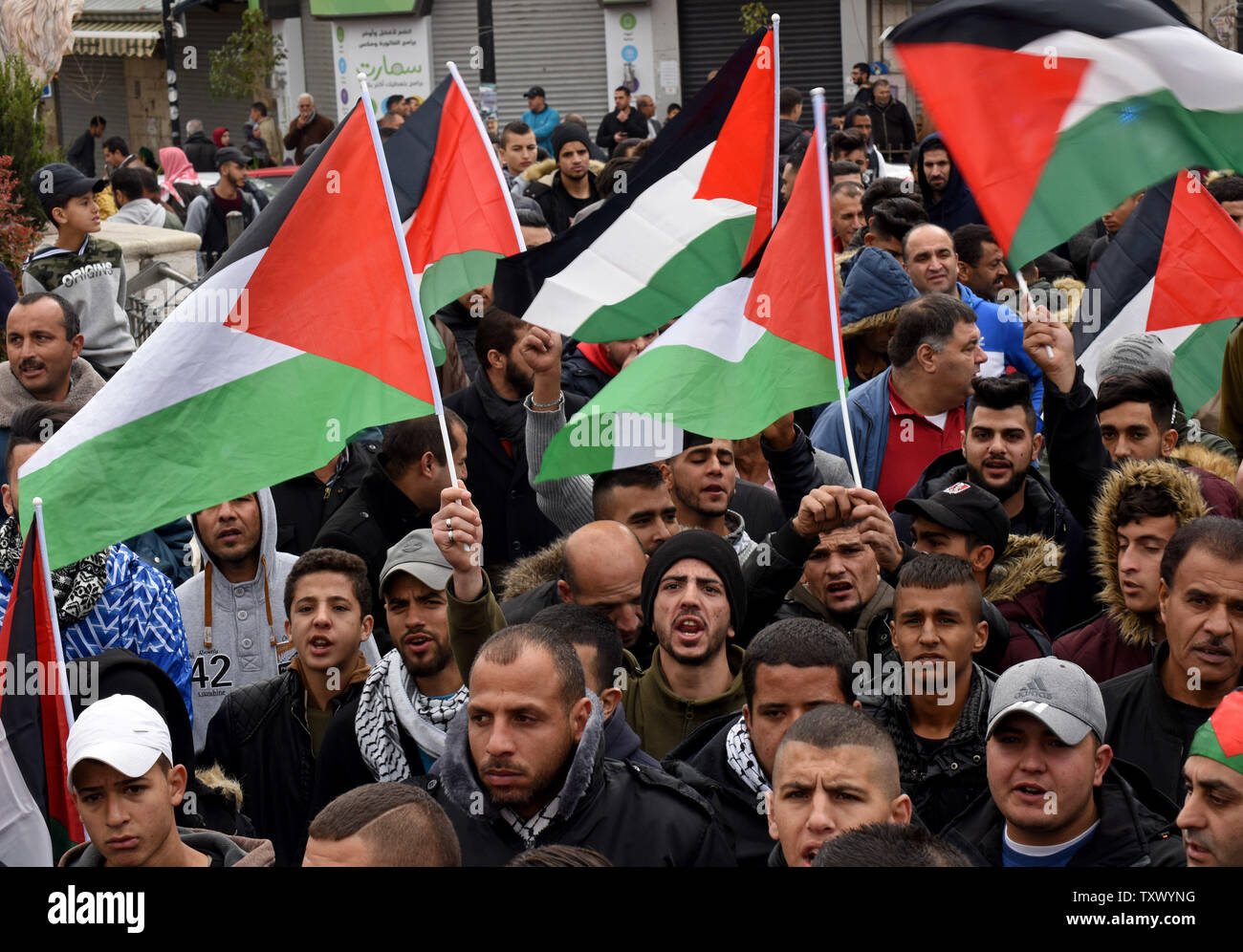 Vague de drapeaux nationaux palestiniens et de chanter des slogans au cours d'une manifestation contre le président américain Donald Trump's reconnaissance de Jérusalem comme capitale d'Israël lors d'une manifestation à Ramallah, Cisjordanie, le 7 décembre 2017. Photo par Debbie Hill/UPI Banque D'Images