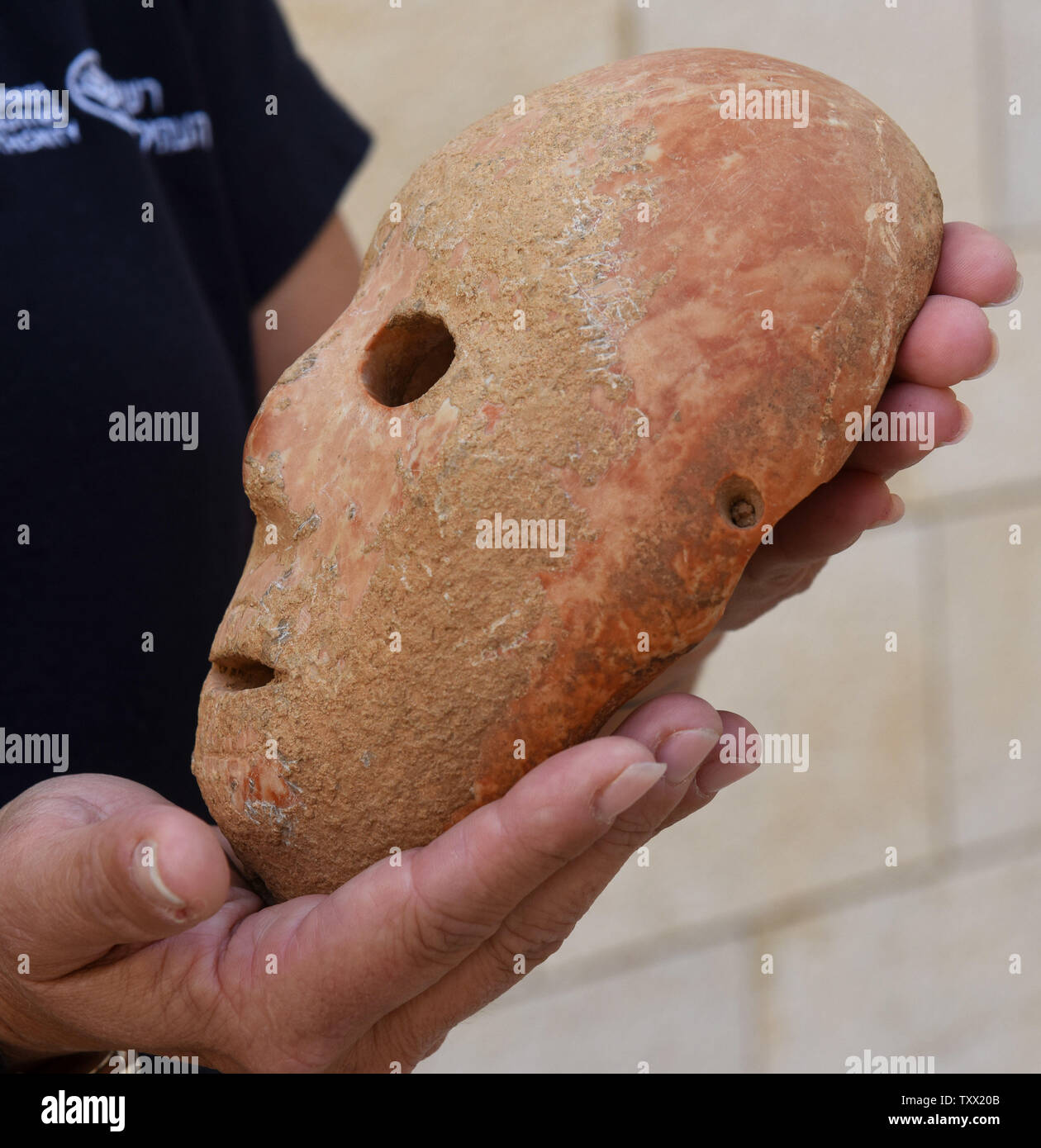 Ronit Lupu de l'Autorité israélienne des antiquités, de l'Unité de prévention de vol d'antiquités est titulaire d'un rare 9 000 ans masque en pierre qui a été découvert dans le sud des collines d'Hébron, au Musée Archéologique Rockefeller à Jérusalem-Est, le 28 novembre 2018. Le masque dates à la période néolithique B et renforce la théorie qu'un centre de production de masque en pierre est situé dans le sud des collines d'Hébron au cours de la nouvelle Âge de pierre. L'Autorité des Antiquités israéliennes et géologique d'Israël étudient le masque et dire que c'était probablement utilisé pour les activités rituelles. Photo par Debbie Hill /UPI Banque D'Images