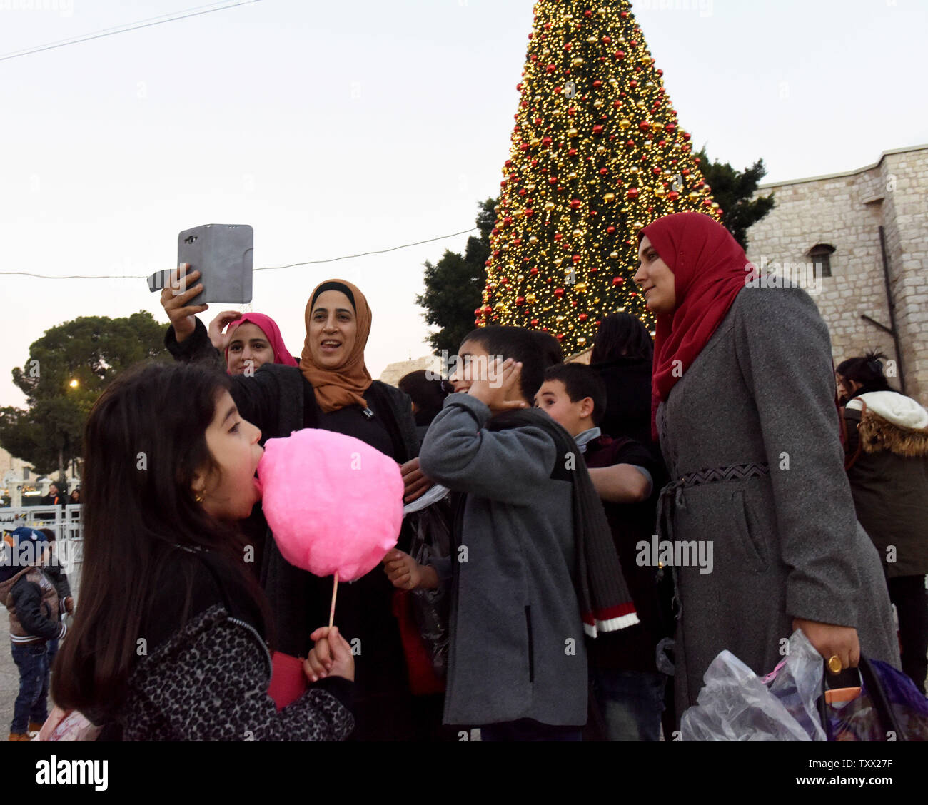 Poser pour une Palestinienne en selfies avant de l'arbre de Noël dans la place de la Crèche, à l'extérieur de l'église de la Nativité, à Bethléem, en Cisjordanie, le 22 décembre 2018. Tous les hôtels de Bethléem sont entièrement réservé pour la veille de Noël. Photo par Debbie Hill /UPI Banque D'Images