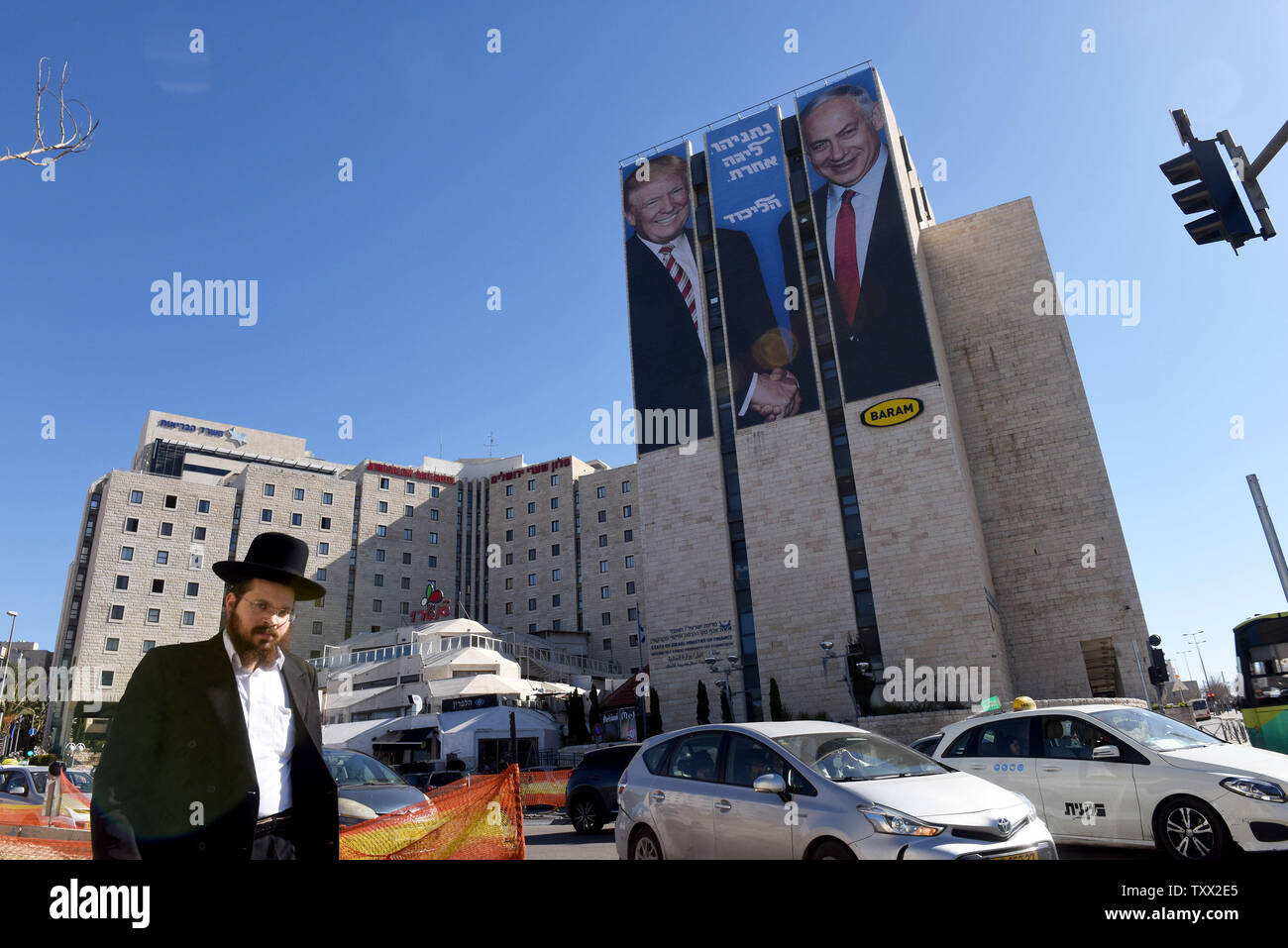 Un Juif ultra-orthodoxes passe devant un panneau publicitaire géant de la campagne électorale Le président américain Donald Trump (L) et le Premier ministre israélien Benjamin Netanyahu ( R) se serrer la main, à l'entrée à Jérusalem, le 4 février 2019. L'hébreu écrit sur le panneau d'affiche "Netanyahou, dans une autre ligue." Les Israéliens se rendront aux urnes dans une élection anticipée le 9 avril 2019. Photo par Debbie Hill/UPI Banque D'Images