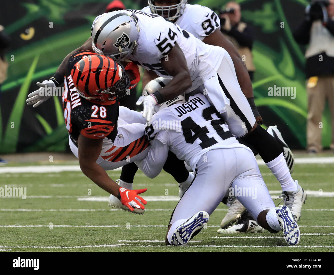 Cincinnati Bengals halfback Joe Mixon (28) est abordé par Oakland Raiders Tahir Whitehead (59) et Karl Joseph (42) au cours de la deuxième moitié de jouer au Stade Paul Brown à Cincinnati, Ohio, le 16 décembre 2018. Photo de John Sommers II /UPI Banque D'Images