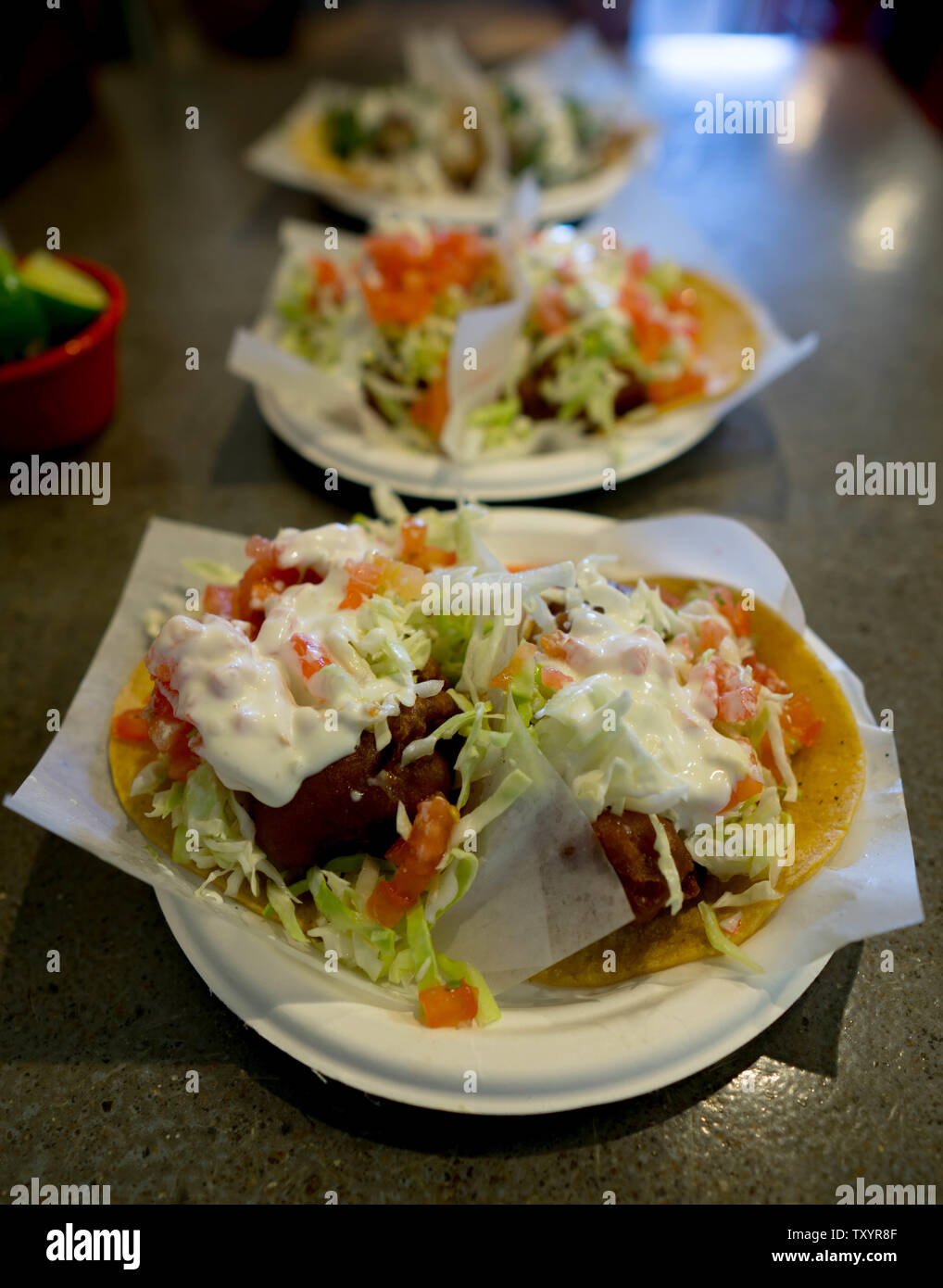 Baja beer battered fish tacos trois assiettes sur une table Banque D'Images