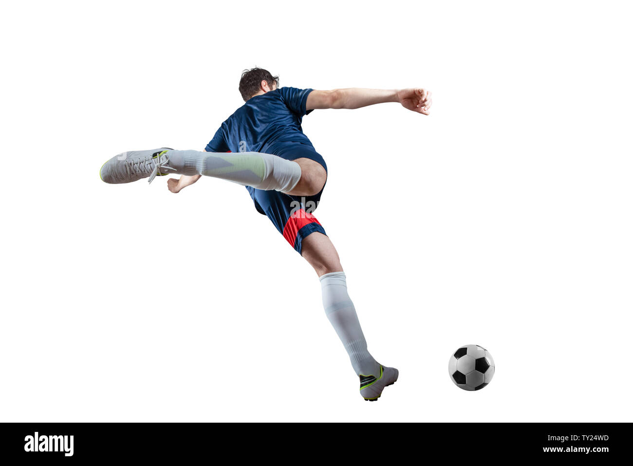 Scène de nuit football match avec player Kicking the ball avec puissance. Isolé sur fond blanc Banque D'Images