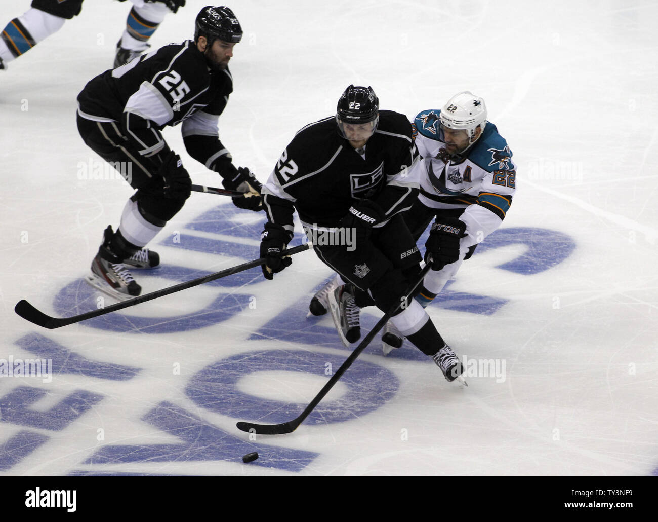 Los Angeles Kings center Trevor Lewis, centre, skates par la défense des Sharks de San Jose le défenseur Dan Boyle, à droite, avec l'aile gauche Kings Dustin Penner (25) traînant sur la pièce pendant la deuxième période de jeu 1 de la Conférence de l'Ouest Playoffs au Staples Center de Los Angeles le 14 mai 2013. UPI/Alex Gallardo Banque D'Images