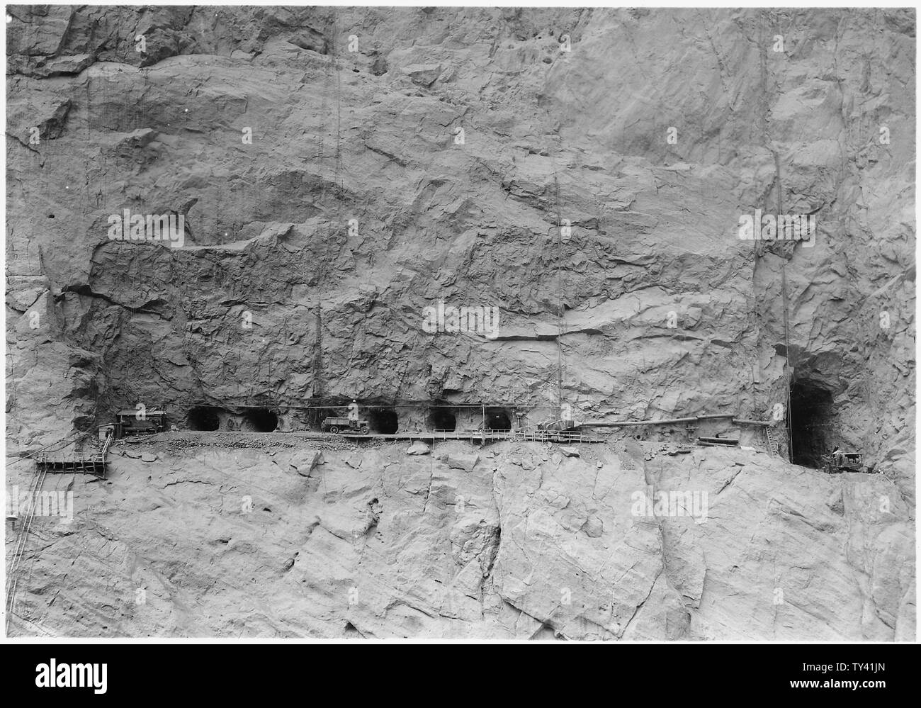 Excavation pour Nevada canyon prise murale fonctionne et conduits. La vue s'directement contre la paroi du canyon et montre l'excavation pour la construction adit à droite. ; Portée et contenu : la photographie de deux volumes d'une série d'albums de photos documentant la construction de barrage Hoover, Boulder City, Nevada. Banque D'Images